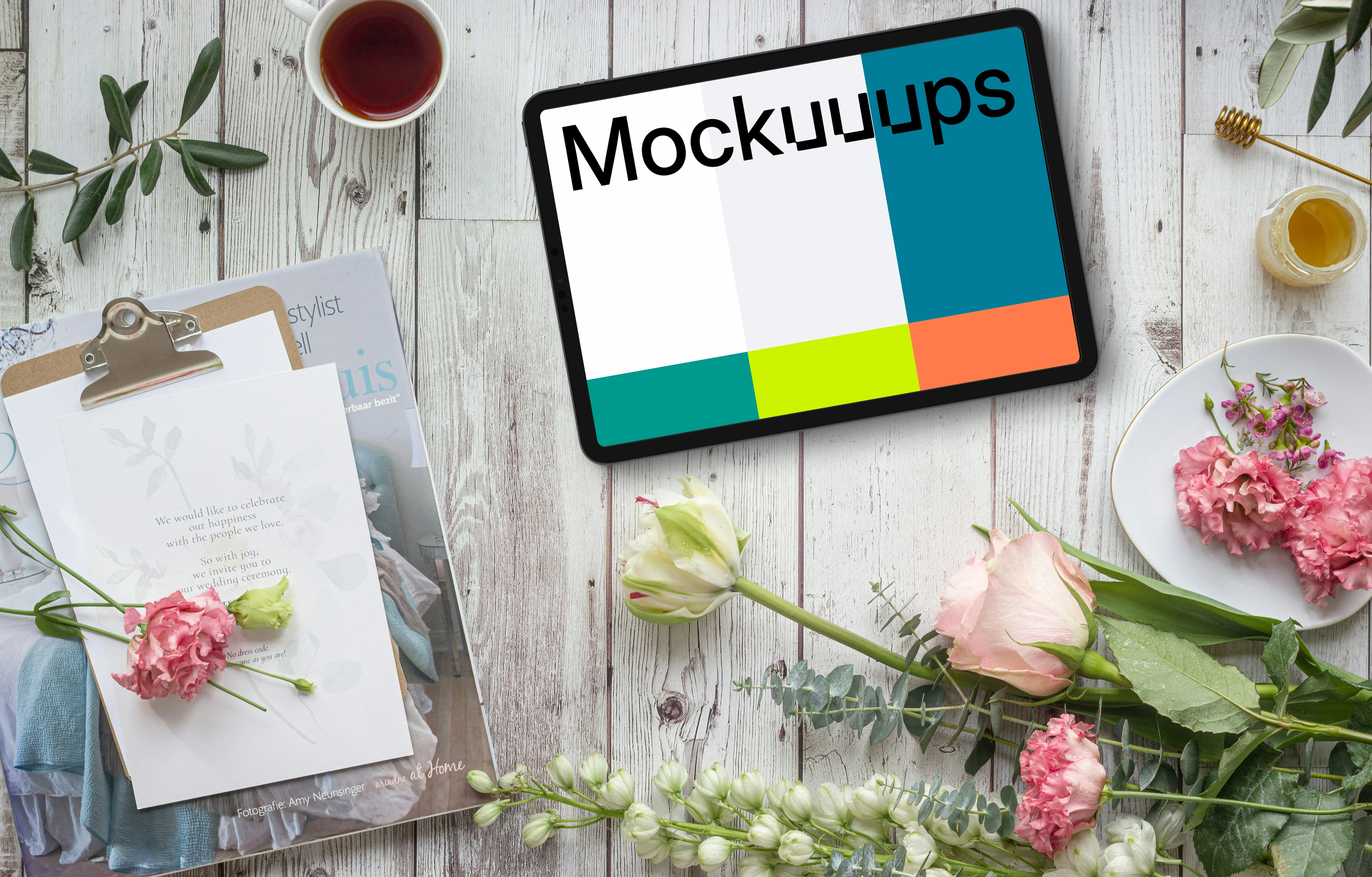 Tablet mockup on white wood decorated by flowers