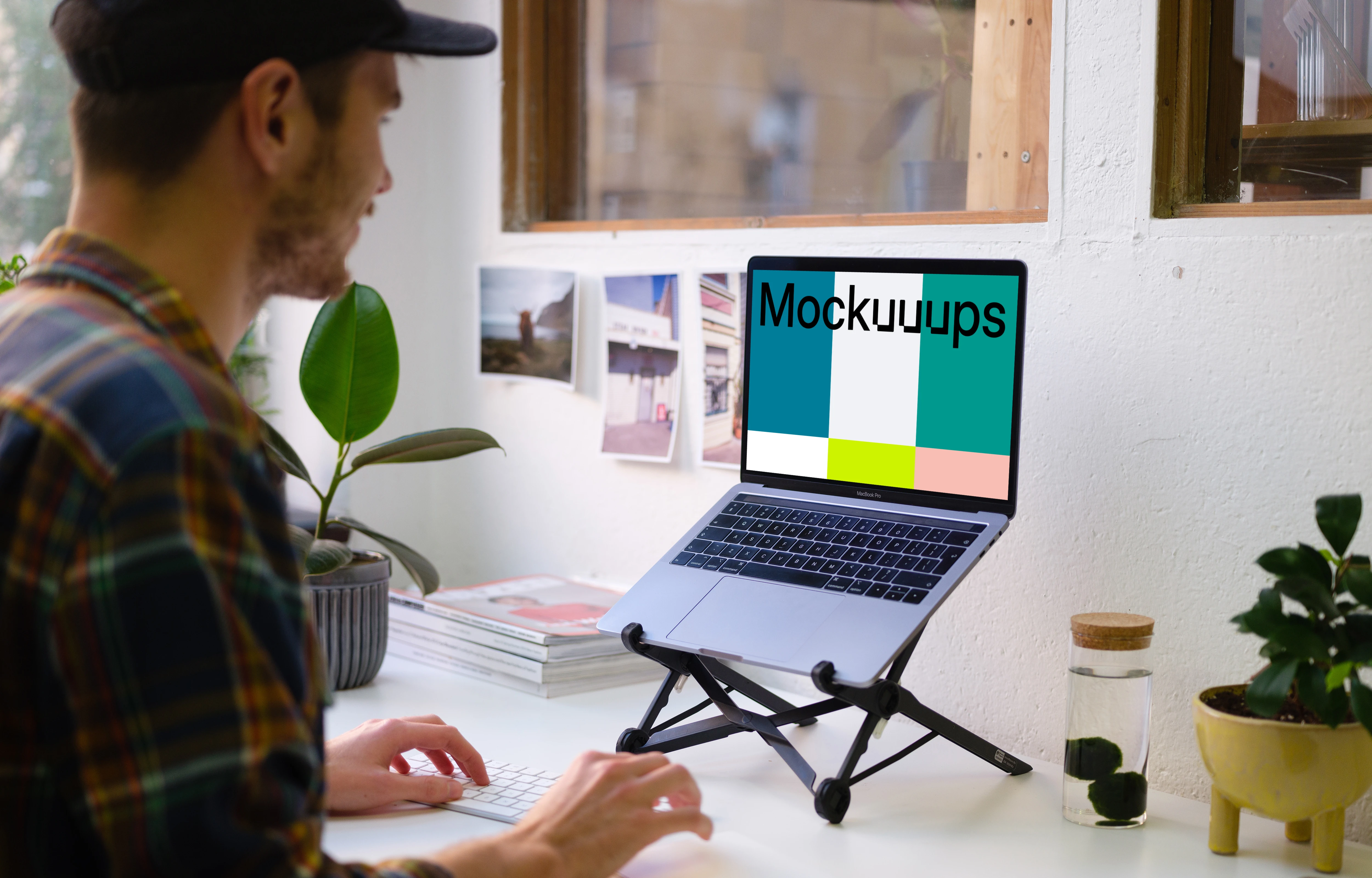 Young man working on the Macbook mockup in the bright office