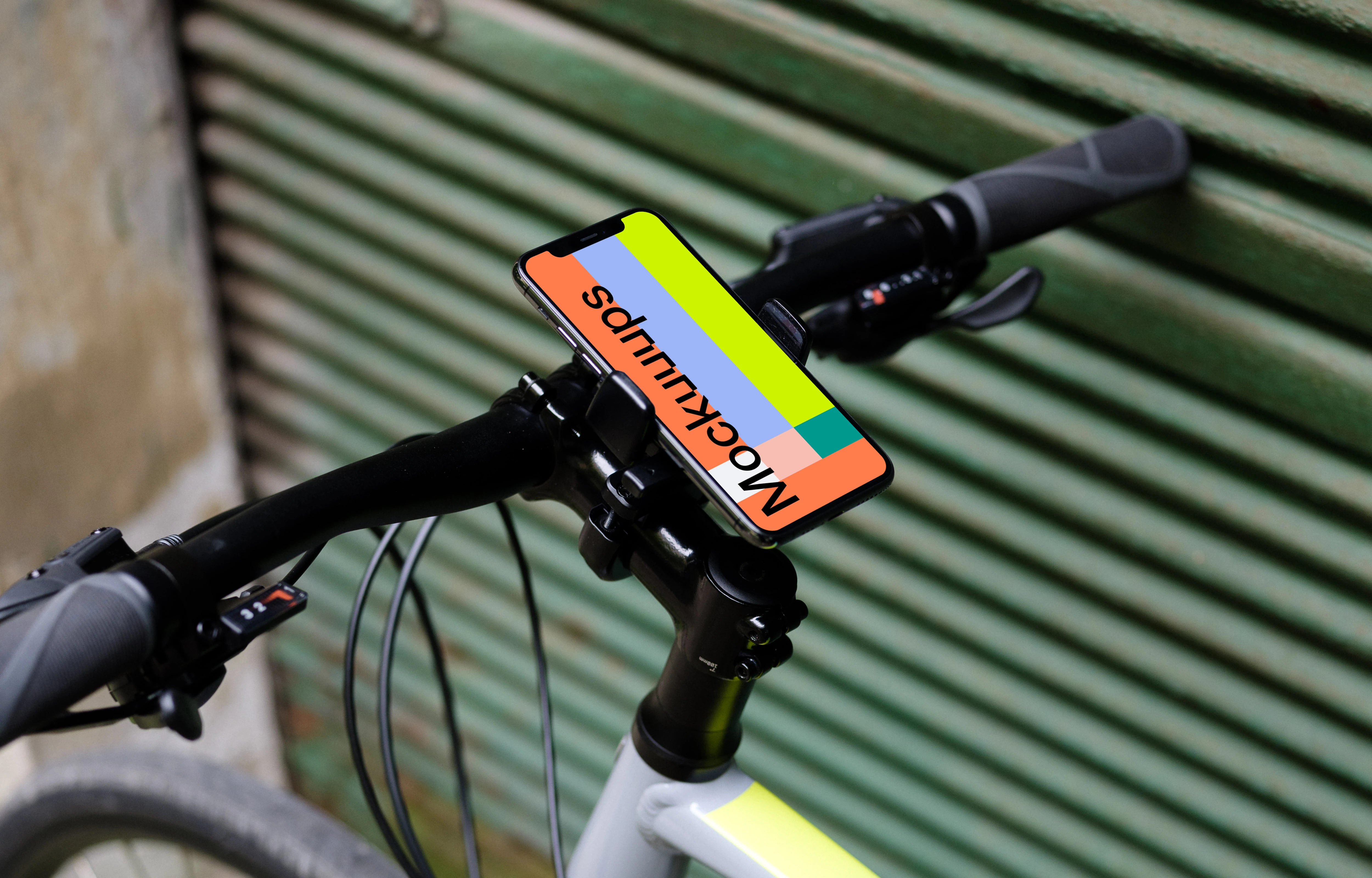 Bike leaned against a garage with iPhone 11 Pro mockup in bike mount
