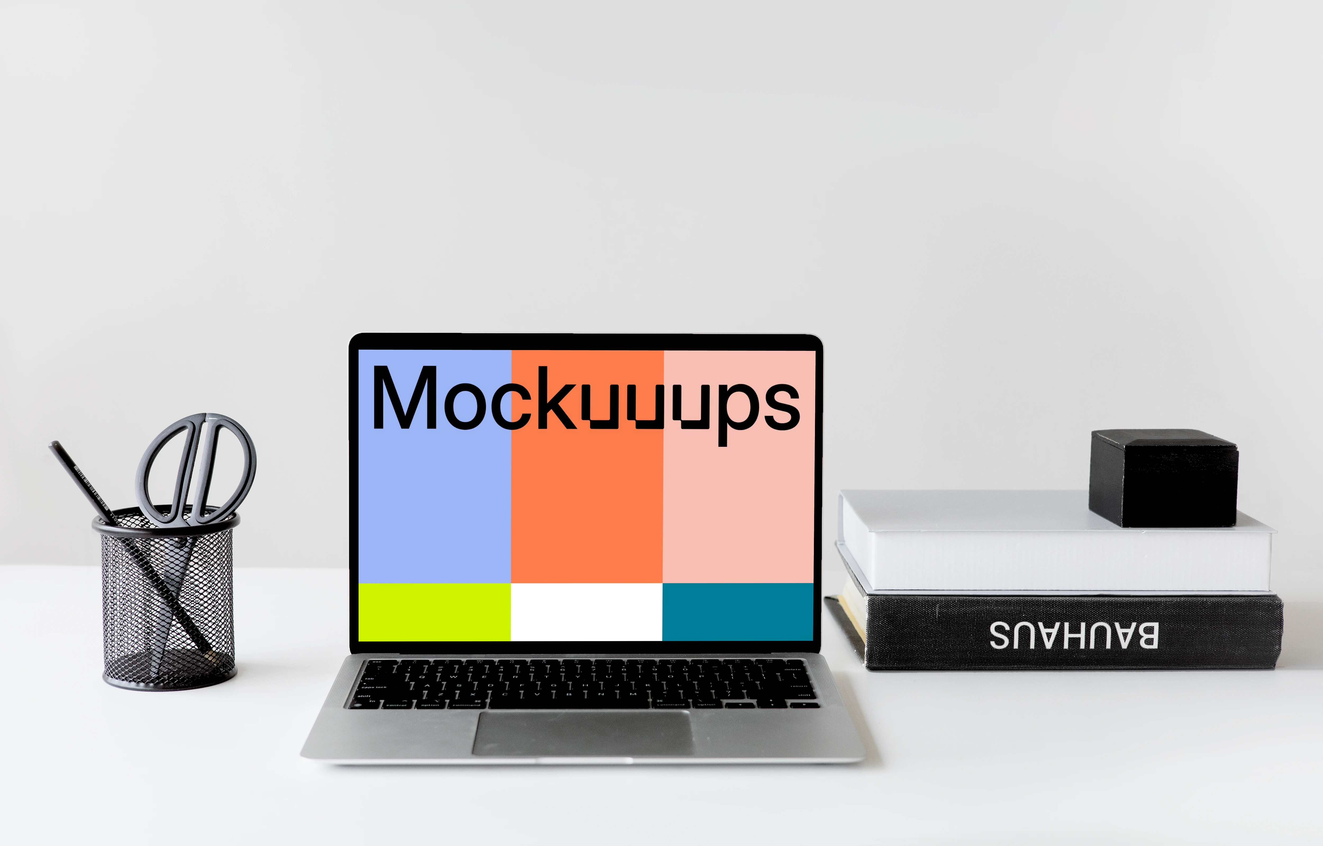 Black MacBook mockup on a white table with black textbooks at the side