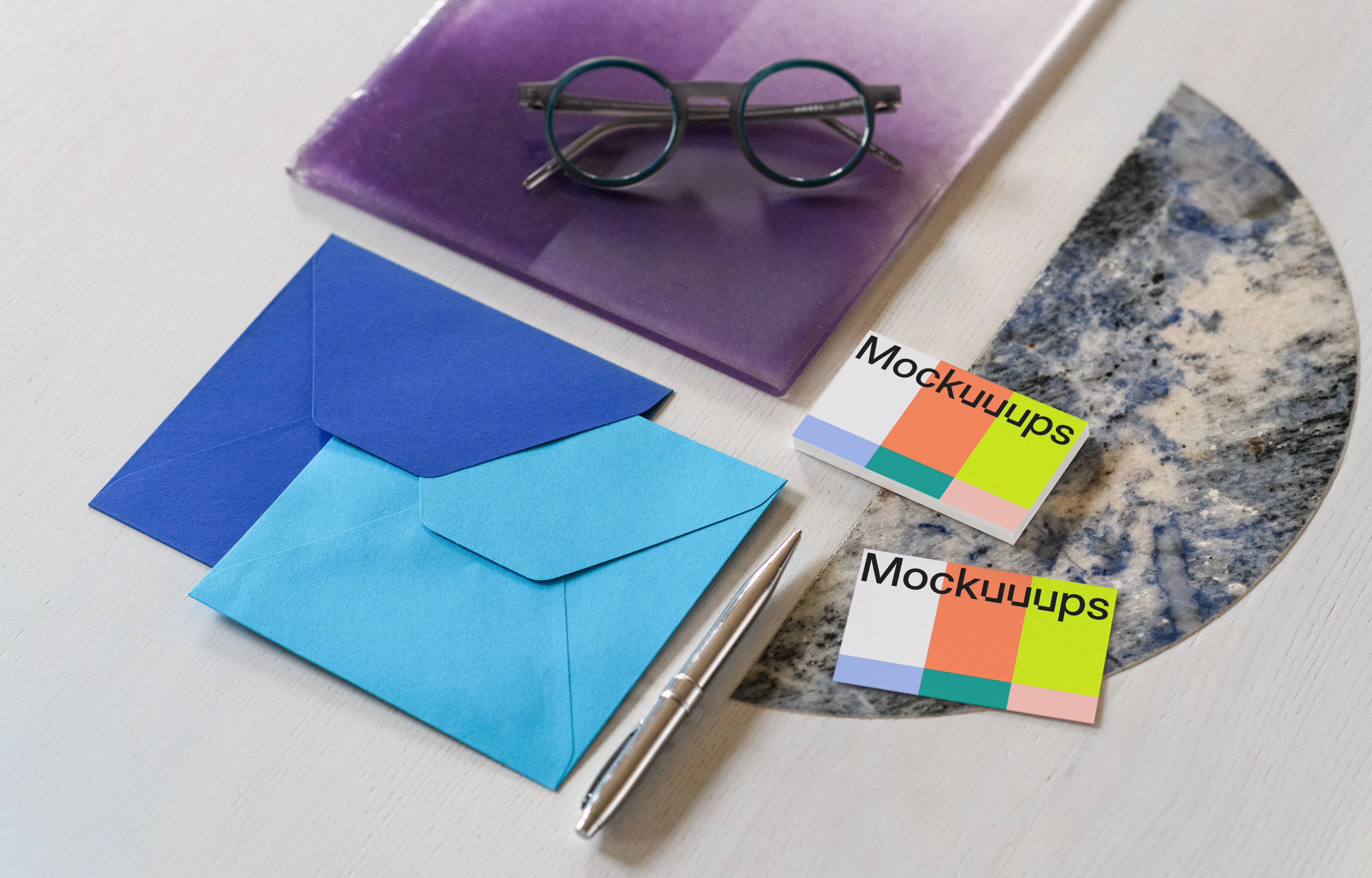 Business card mockup with colorful envelopes on a styled surface