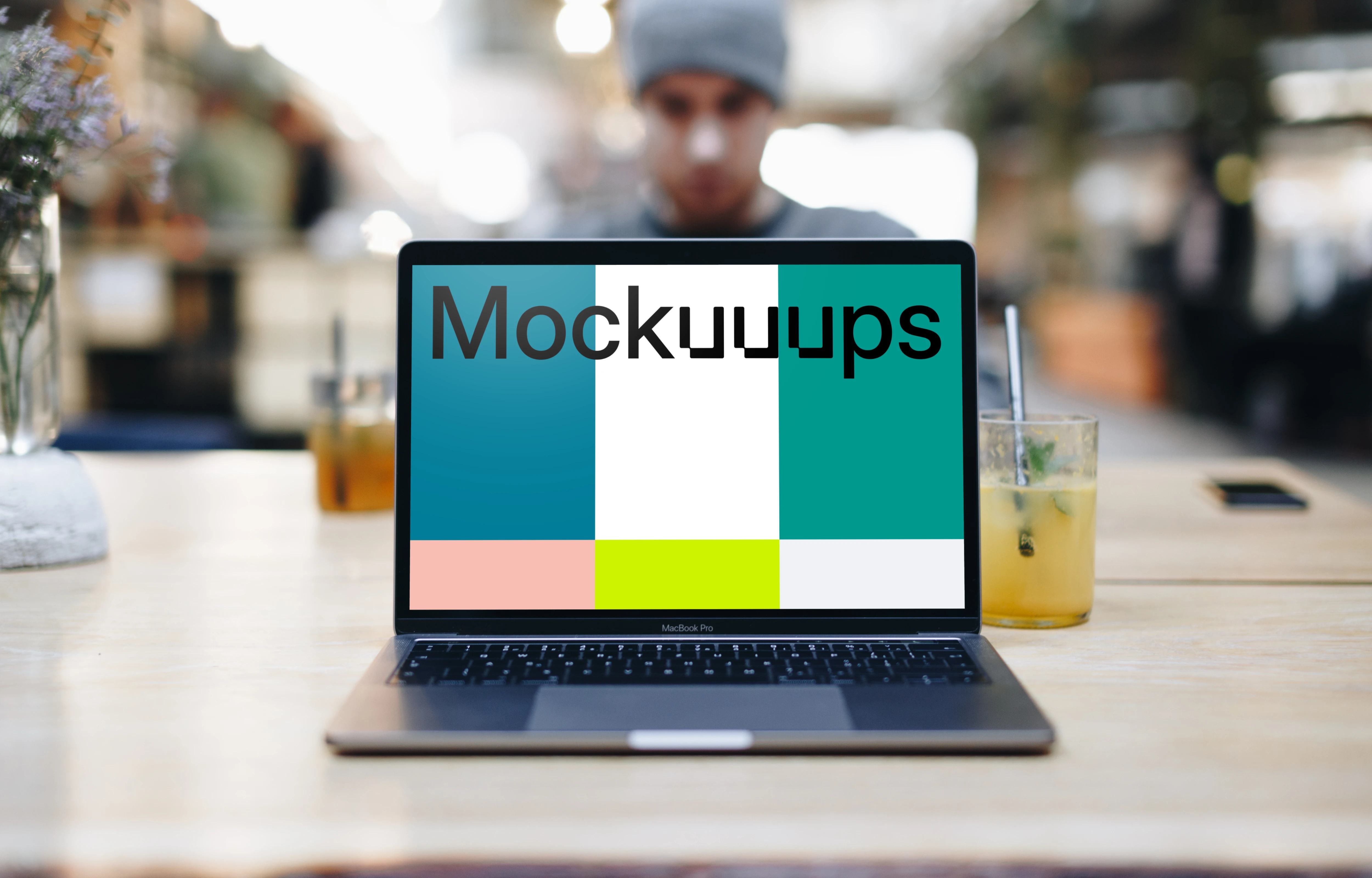 Front view of Macbook Pro mockup with co-worker behind