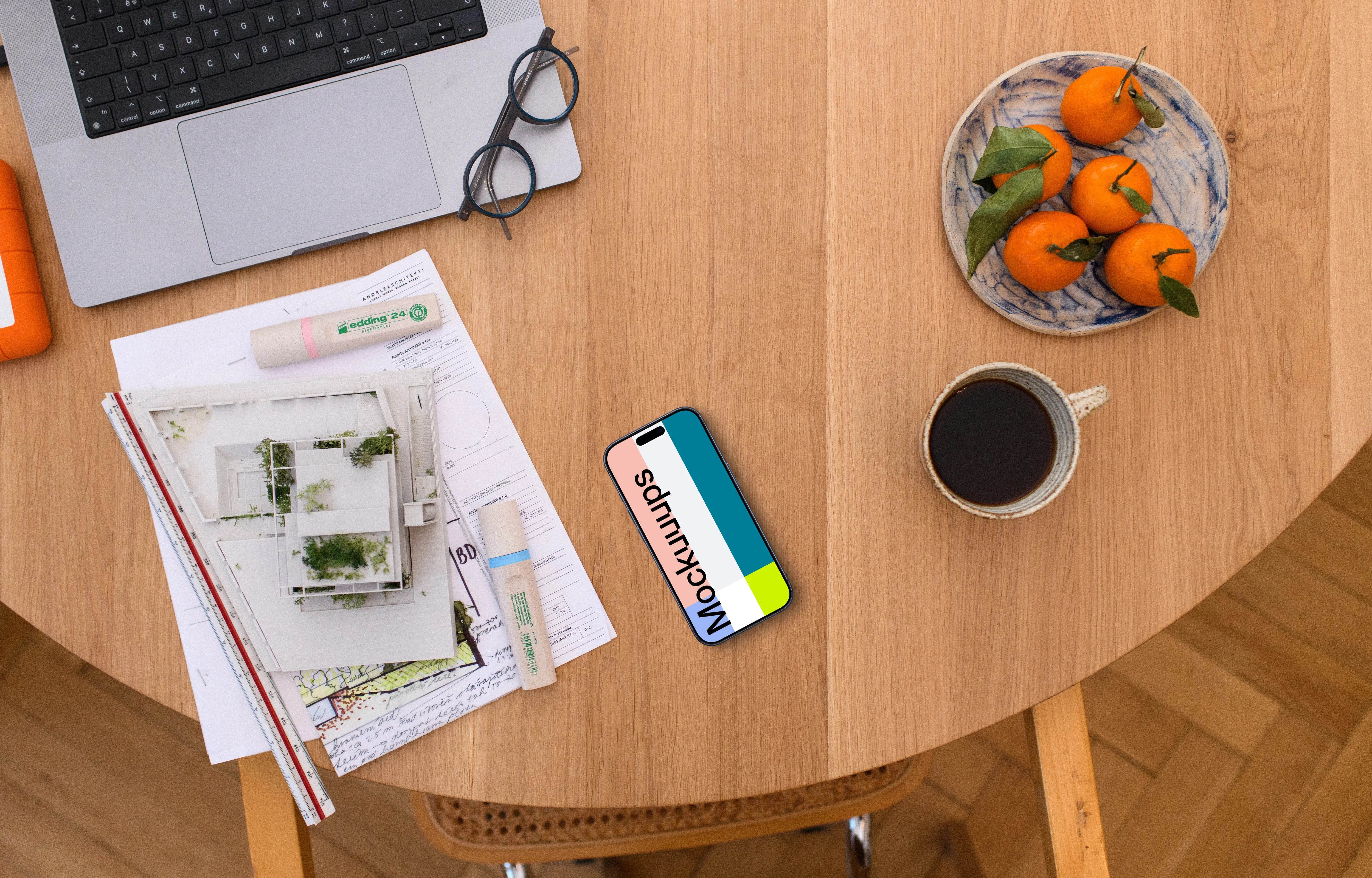 Smartphone mockup with architectural plans on a wooden table