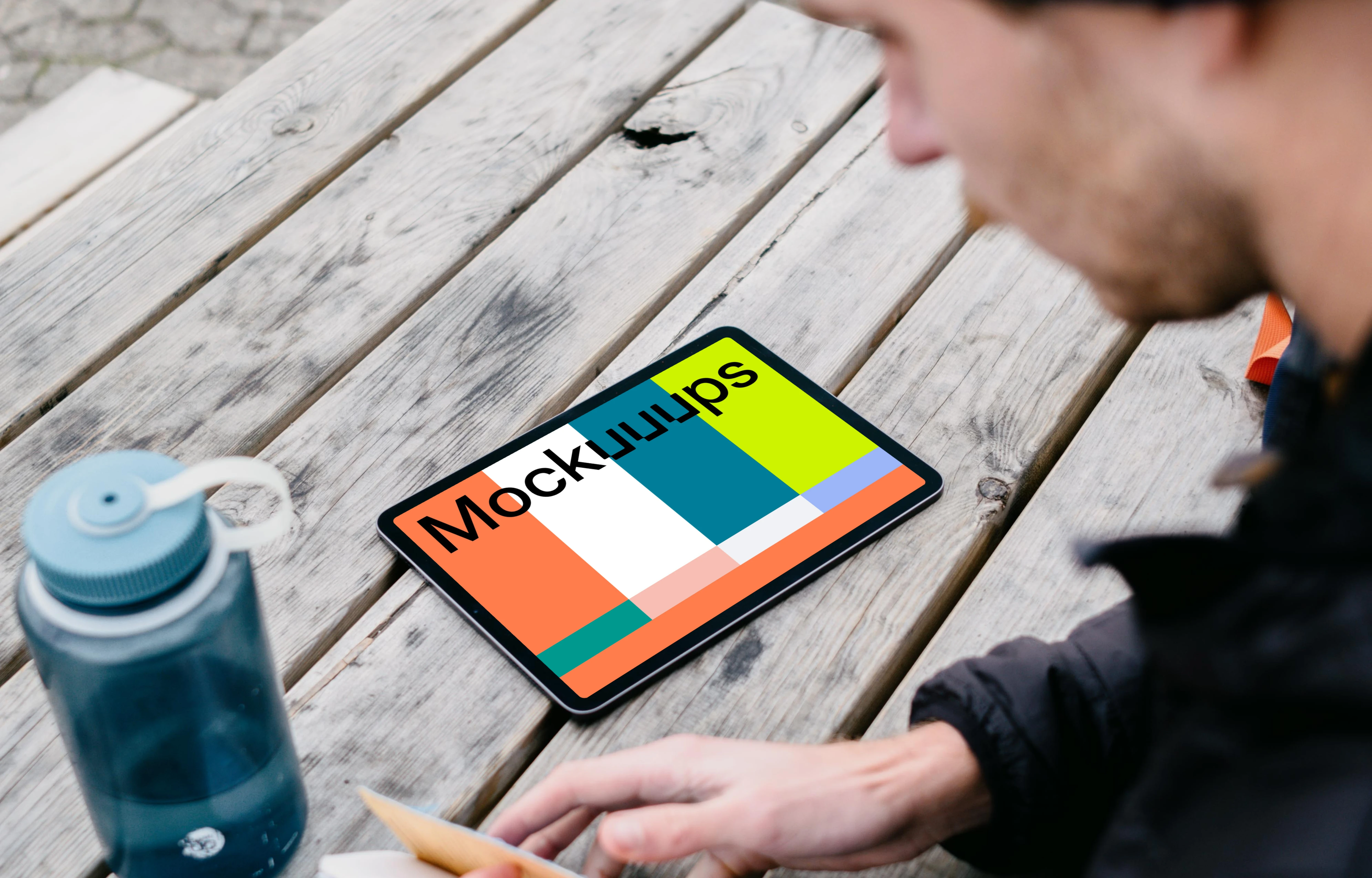 iPad Air mockup on a park table beside a water bottle
