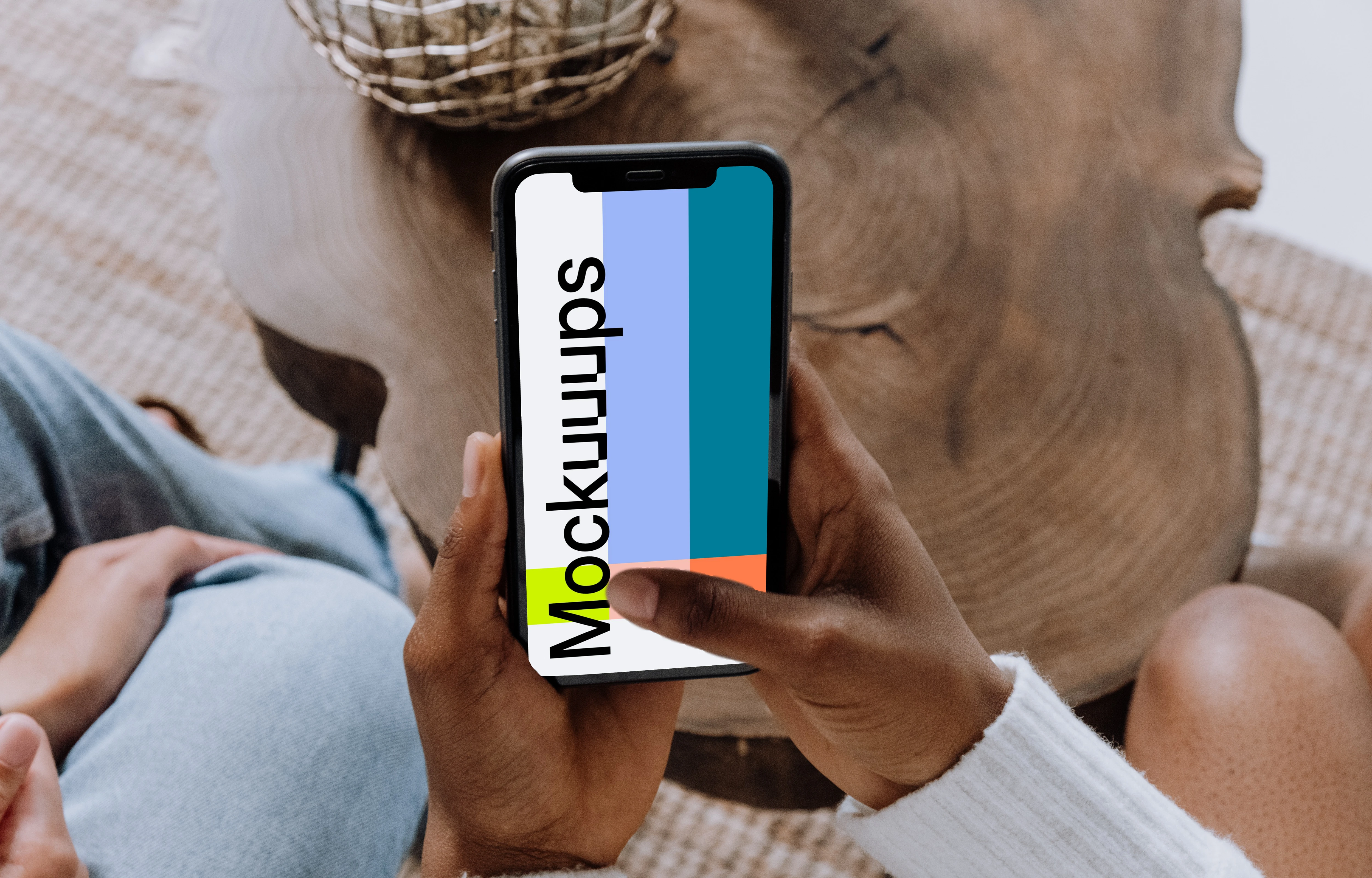 iPhone mockup held above a wooden table