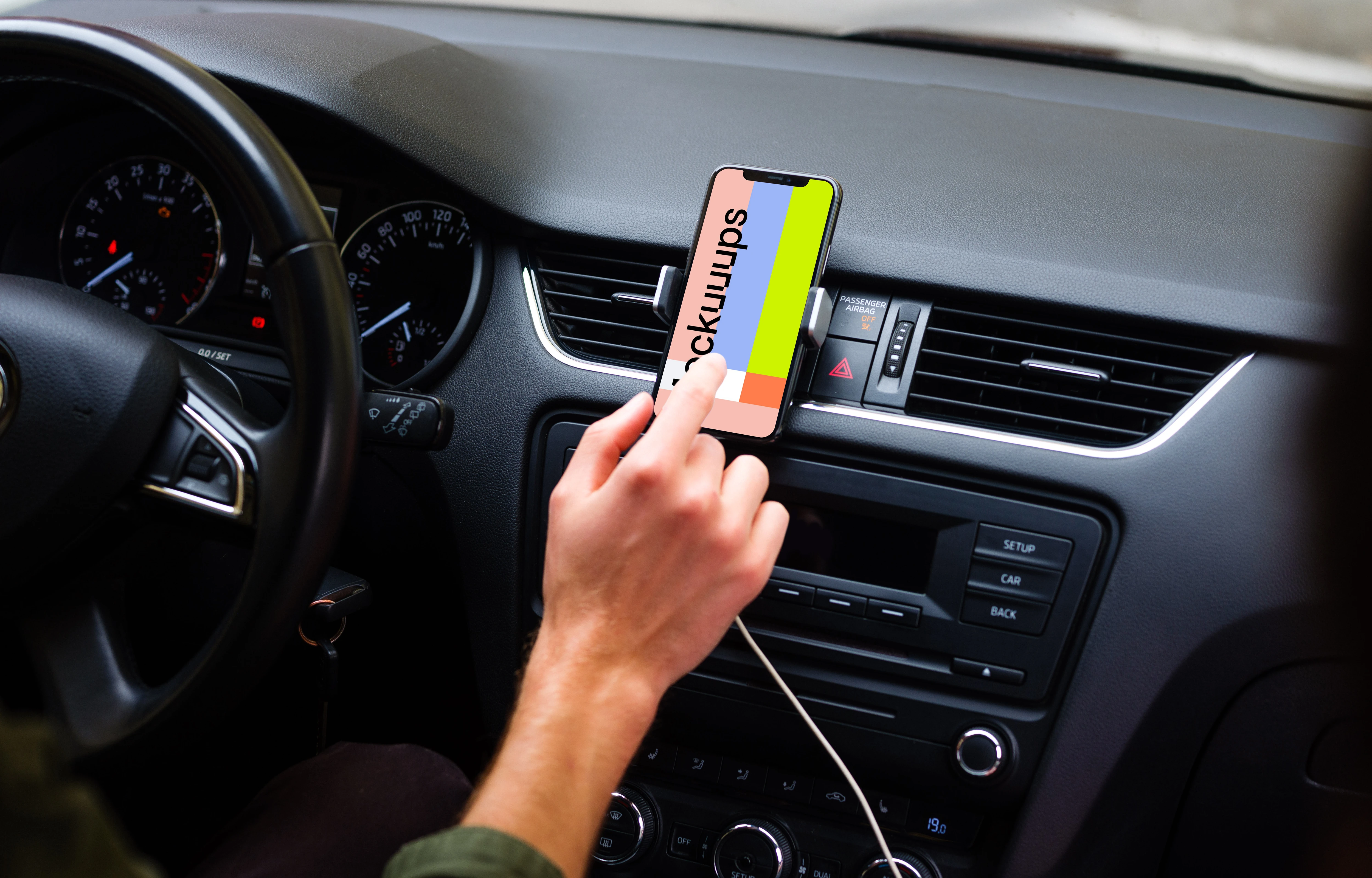 Driver interacting with iPhone 11 mockup in car mount