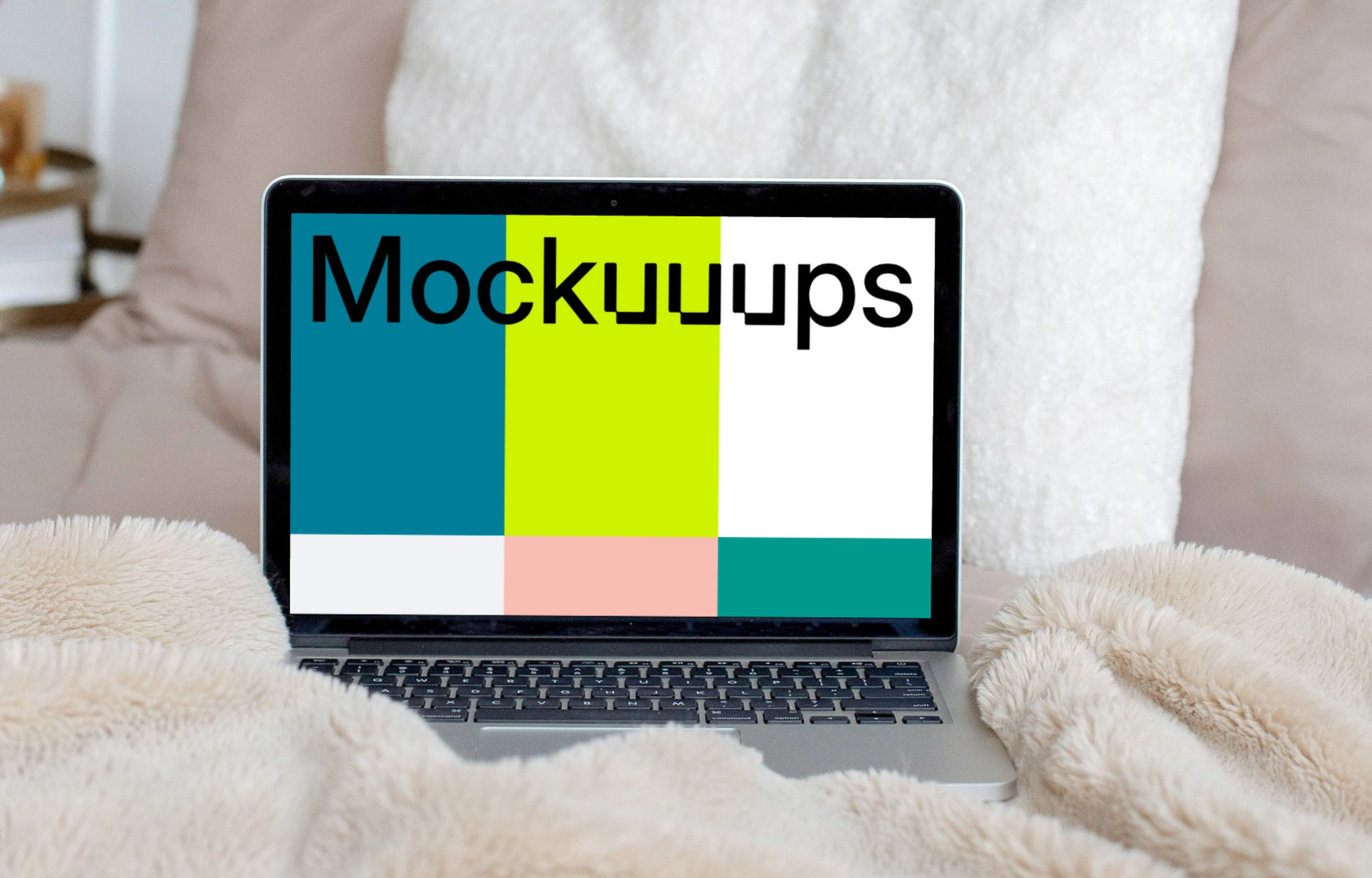 MacBook mockup on a cream-colored bed with white pillows in the background