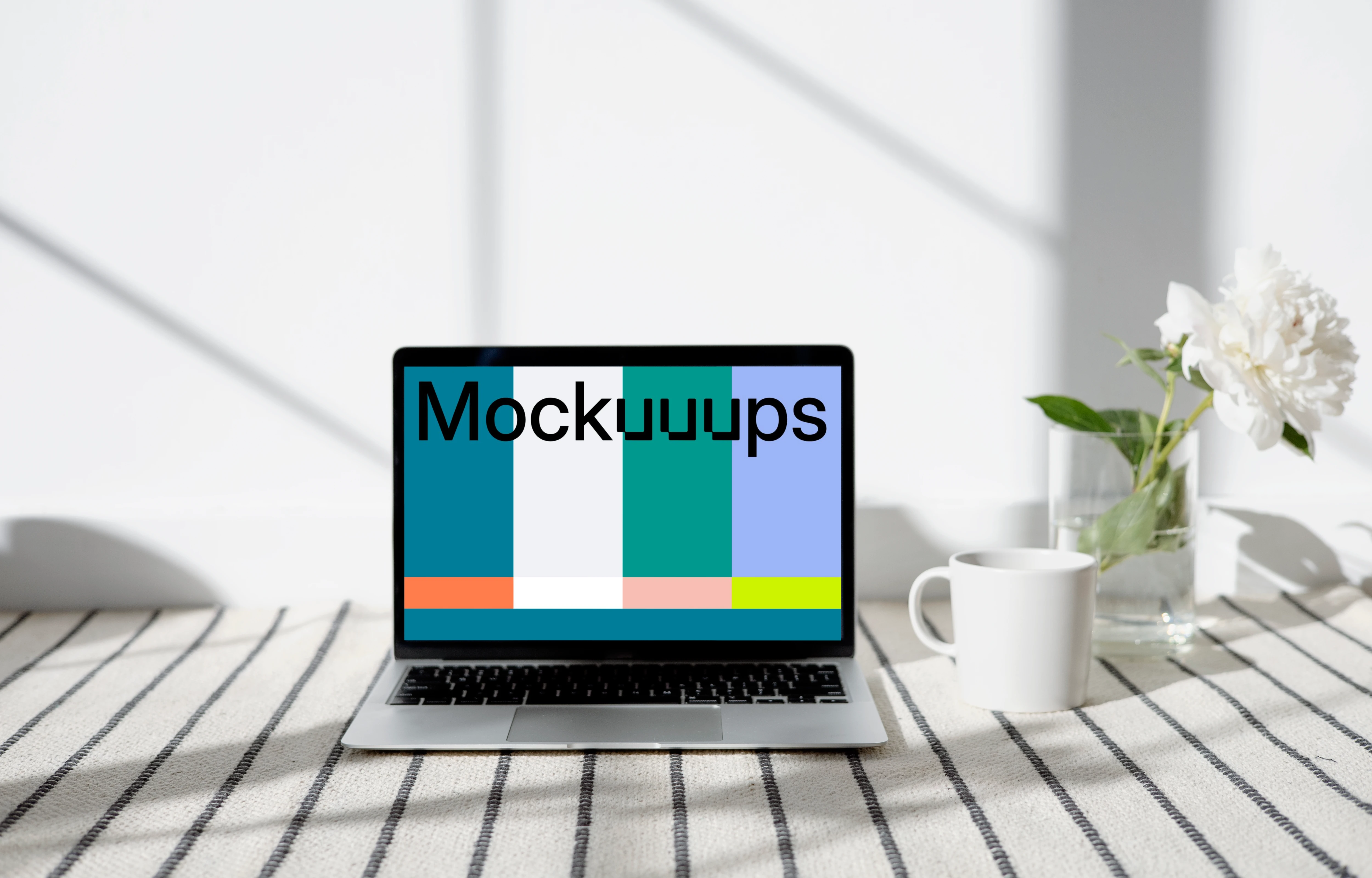 MacBook mockup on a patterned carpet with a cup at the side