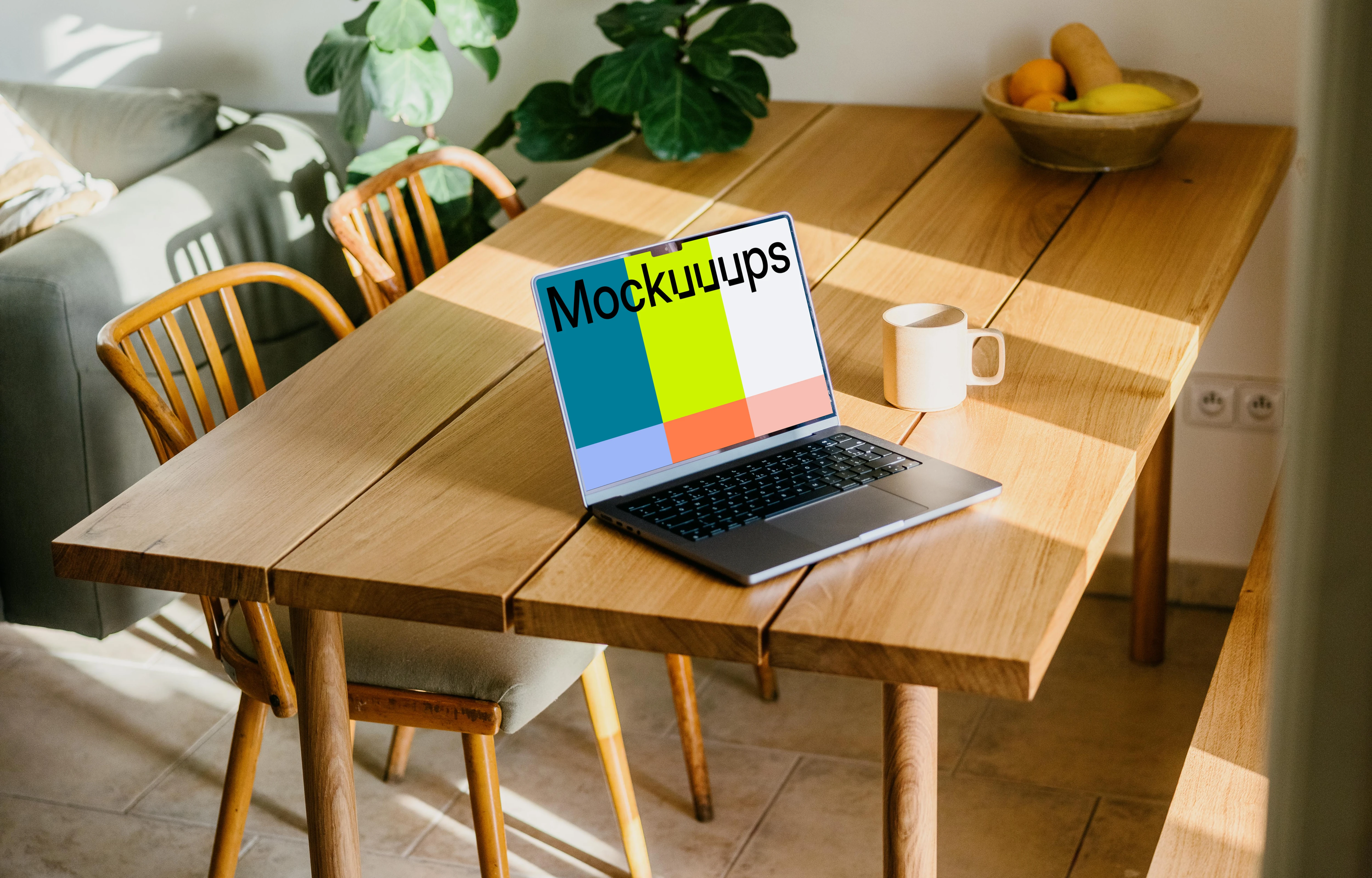 MacBook mockup on a table beside a coffee mug