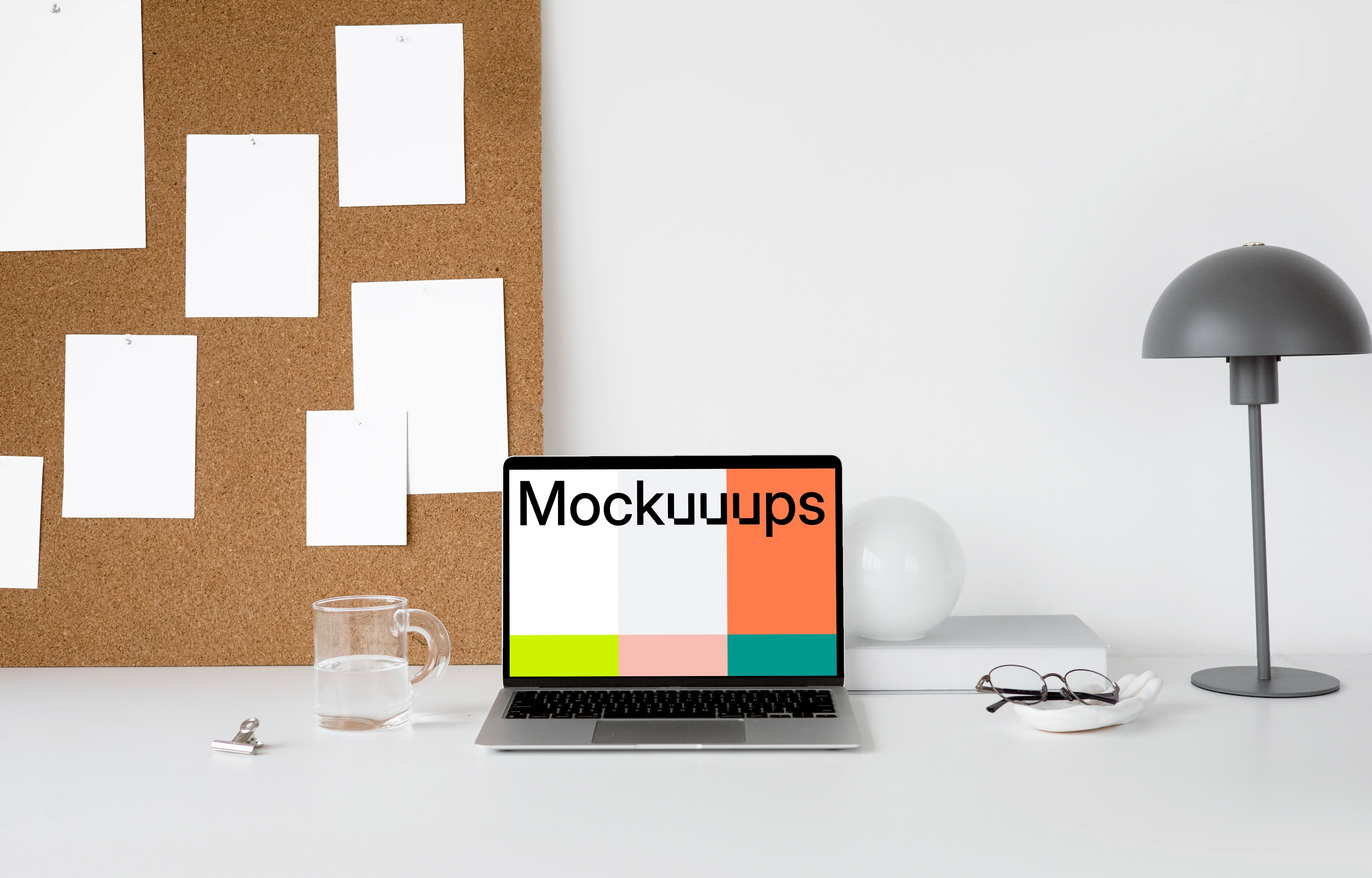MacBook mockup on a white workstation table with task board at the side