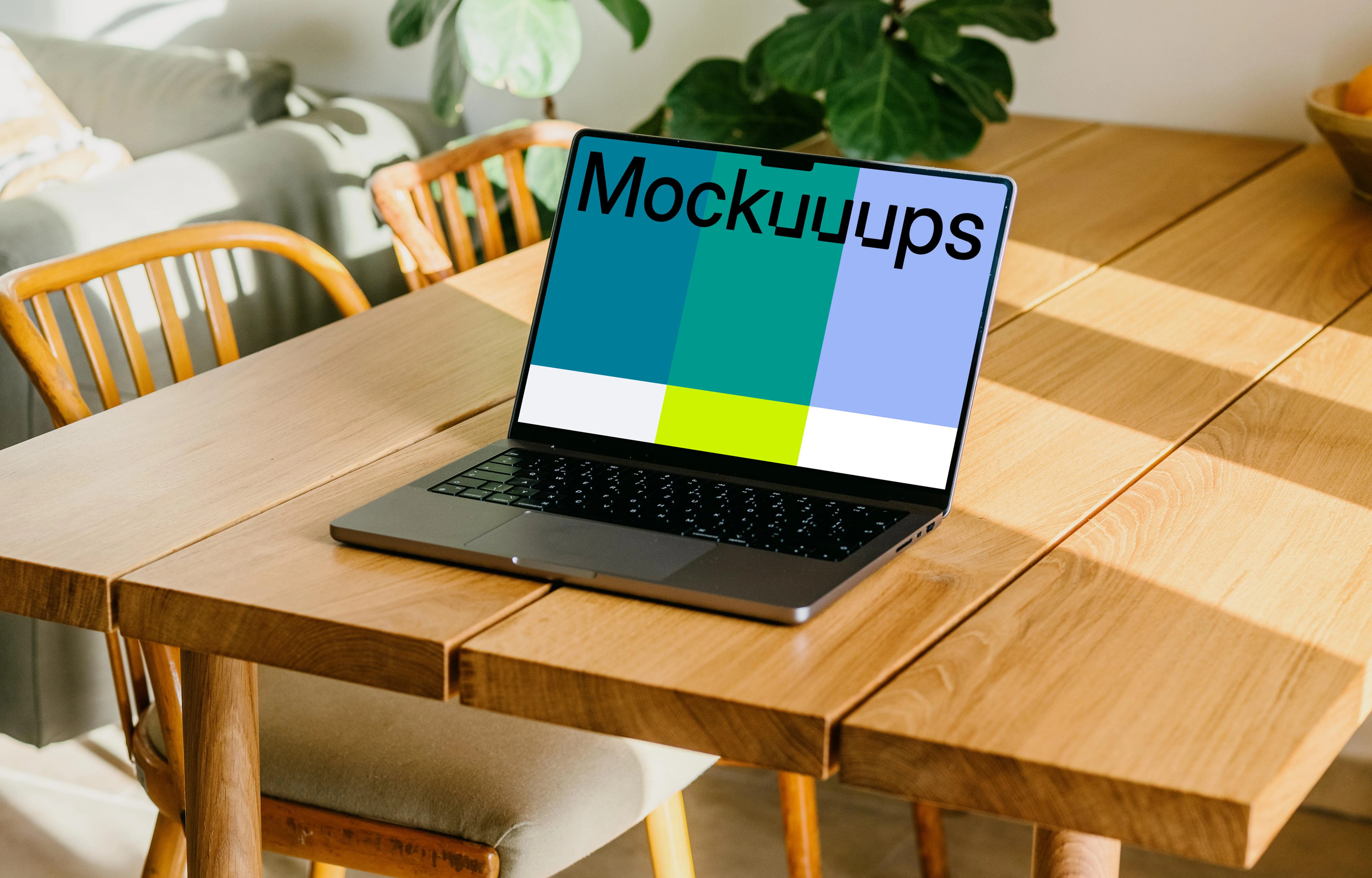 Free MacBook Pro mockup on a table with a plant in the background