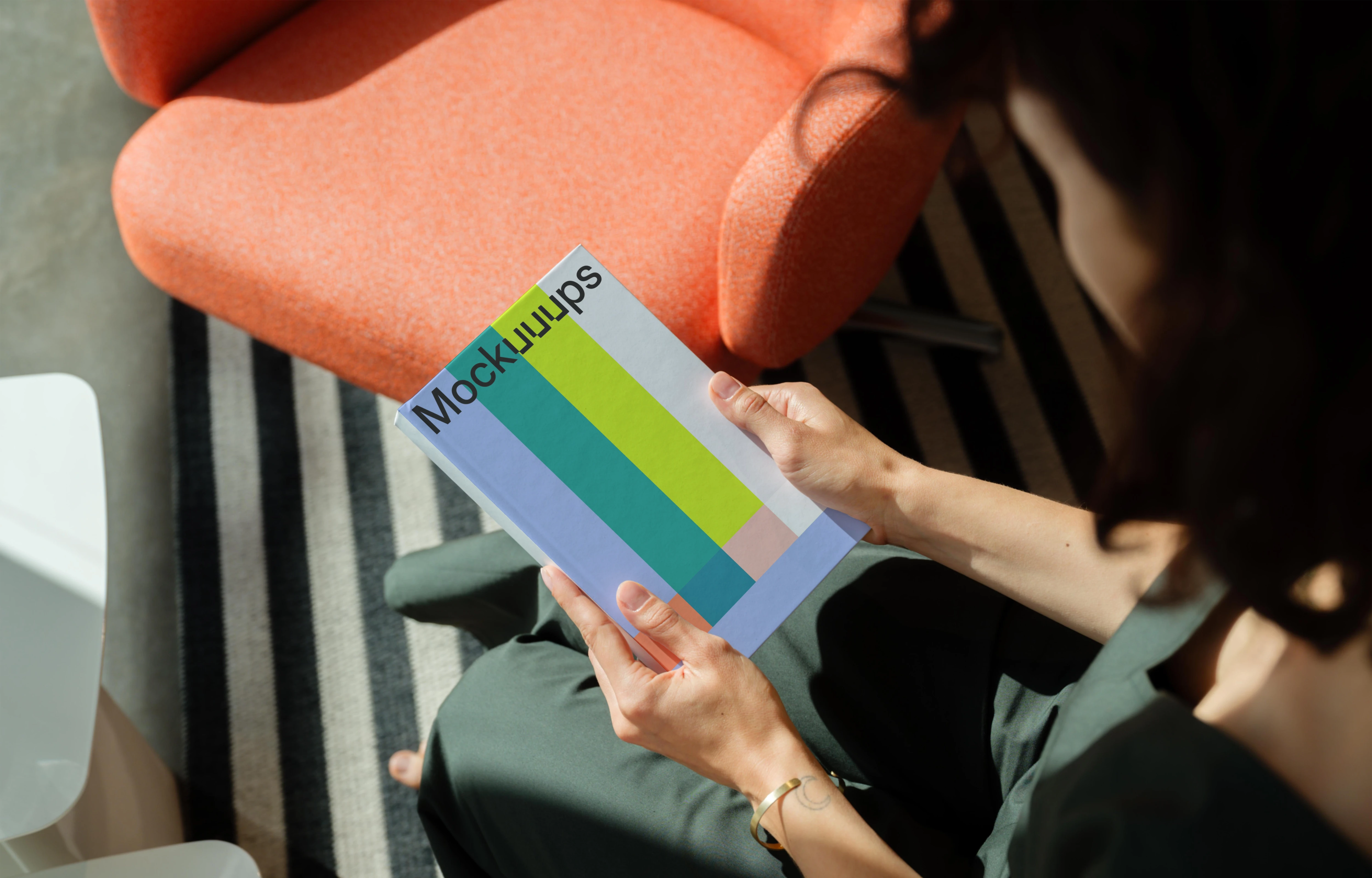 Mockup of a book held in hands with a modern interior background