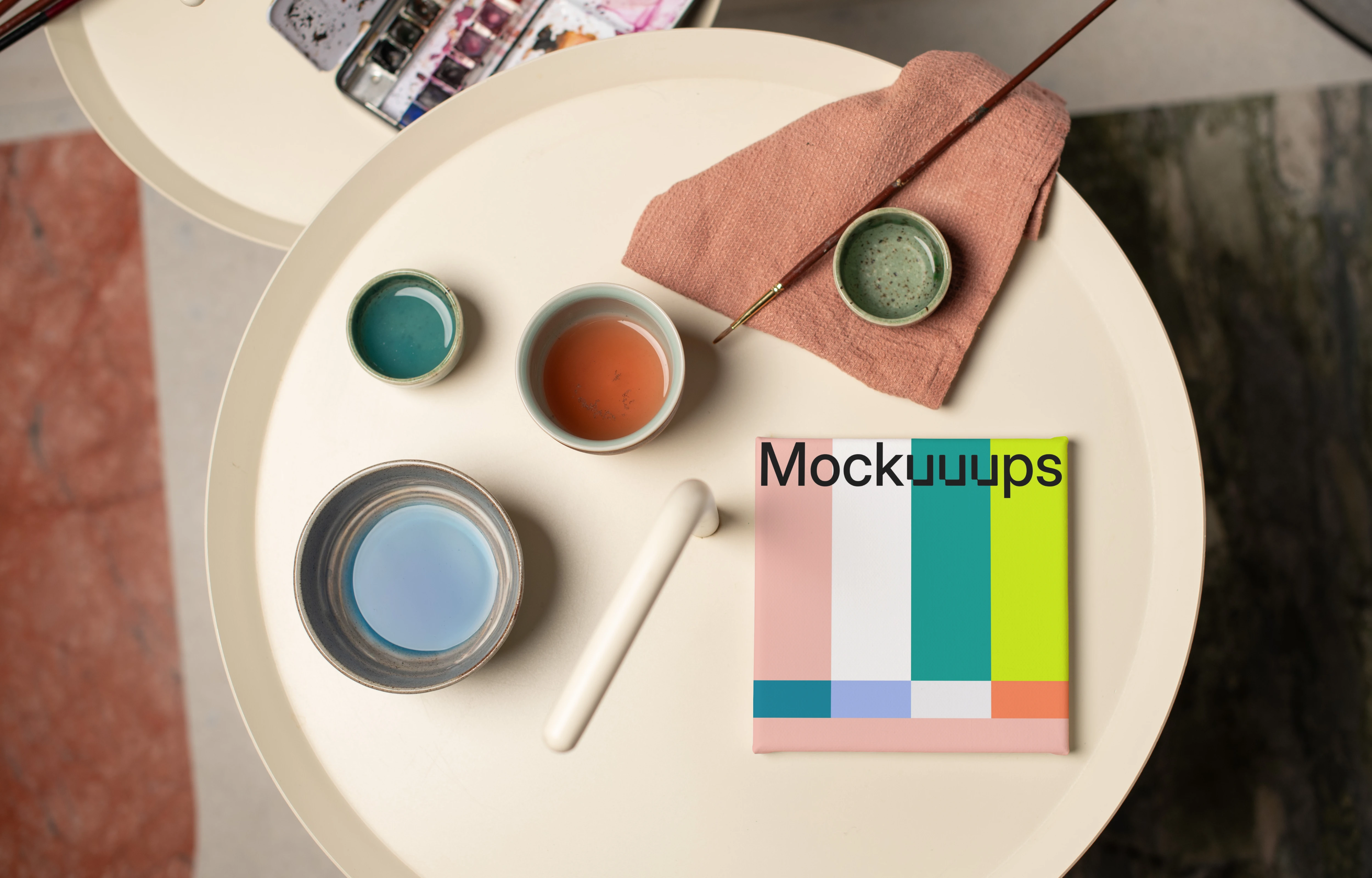 Mockup of a square poster with art supplies on a round table