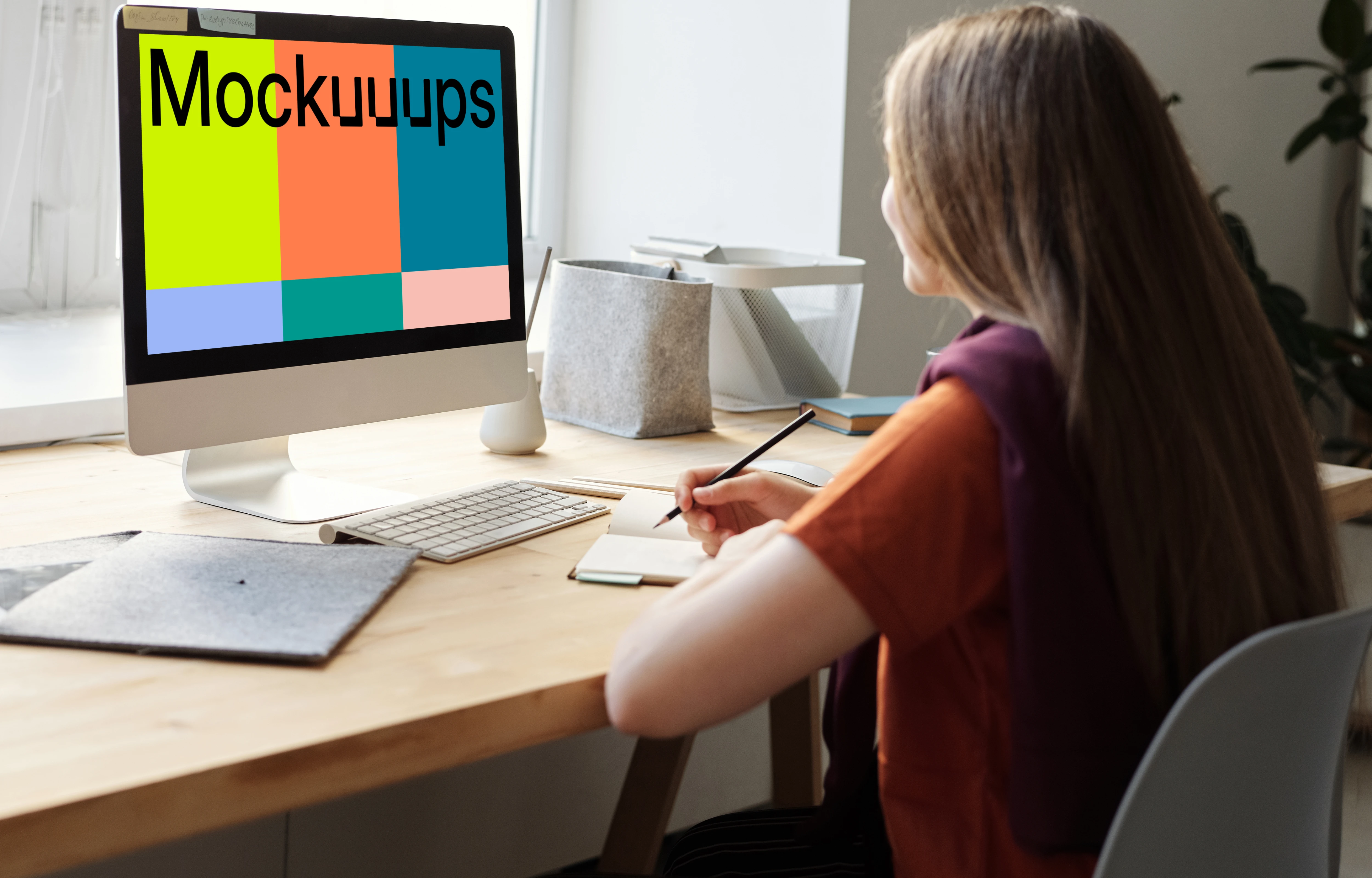 Mockup of a young girl using her iMac on a table
