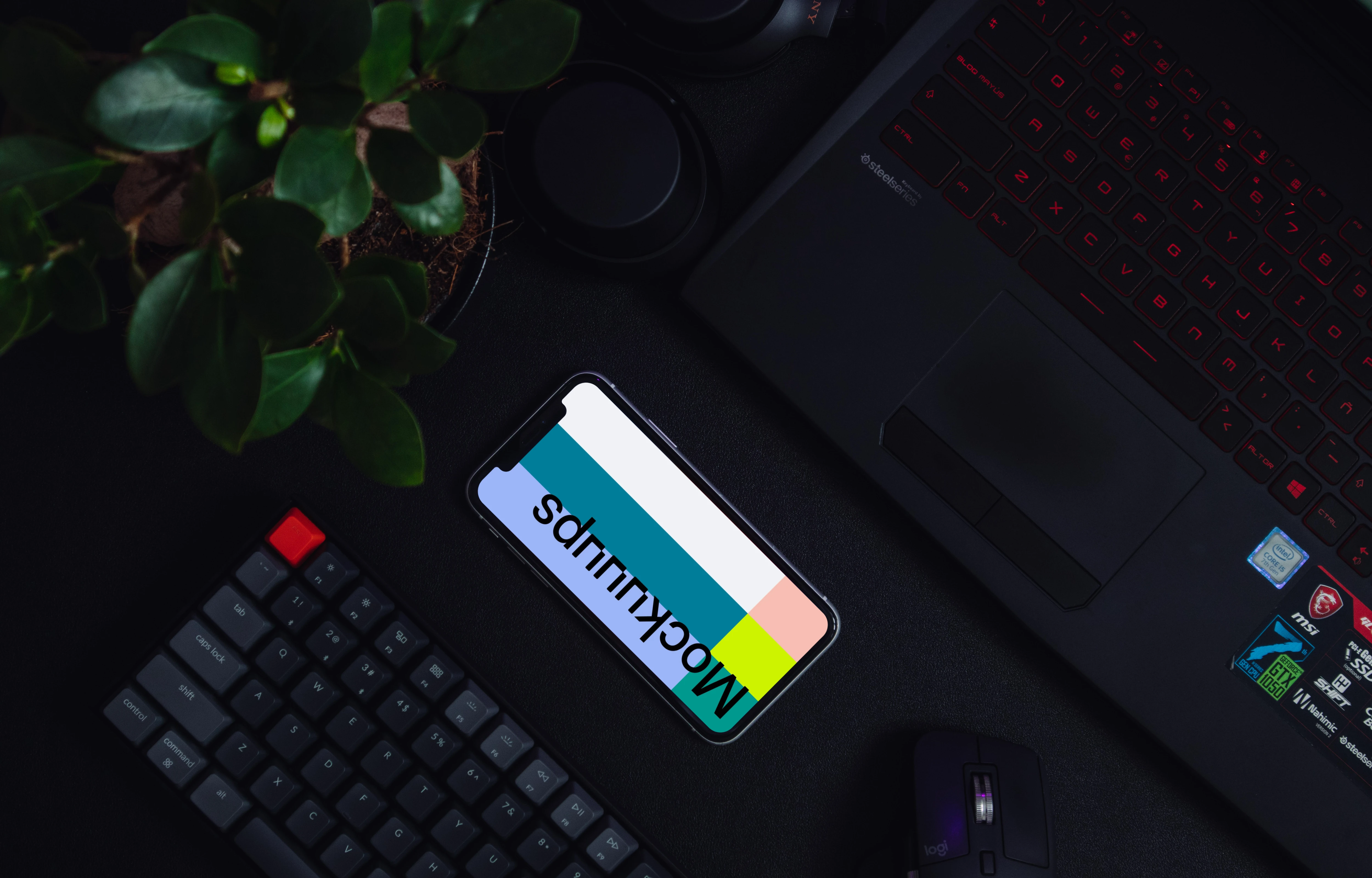 Night iPhone mockup on a table alongside a keyboard and flower pot