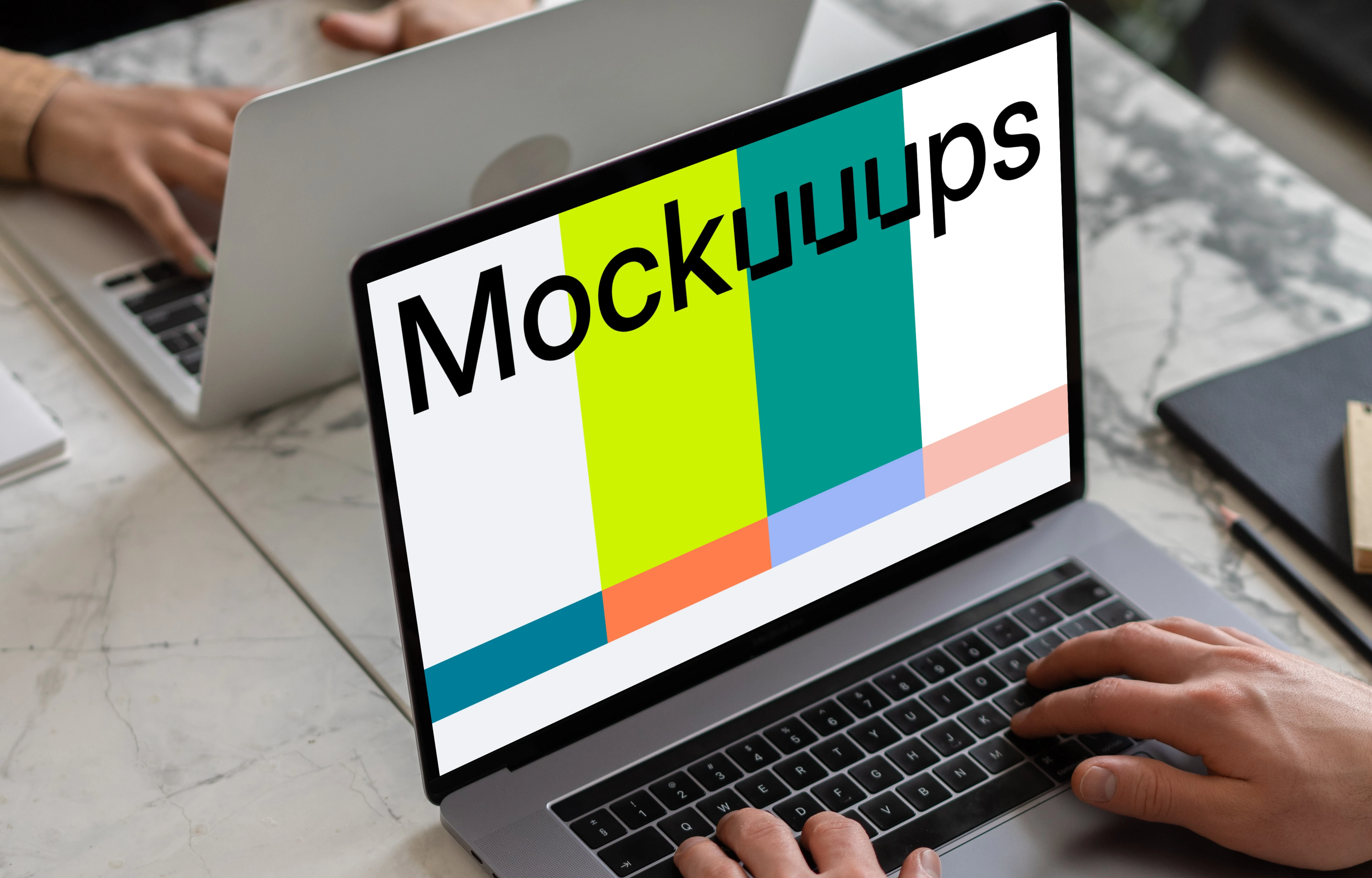 Notebook mockup on a table opposite another MacBook Pro