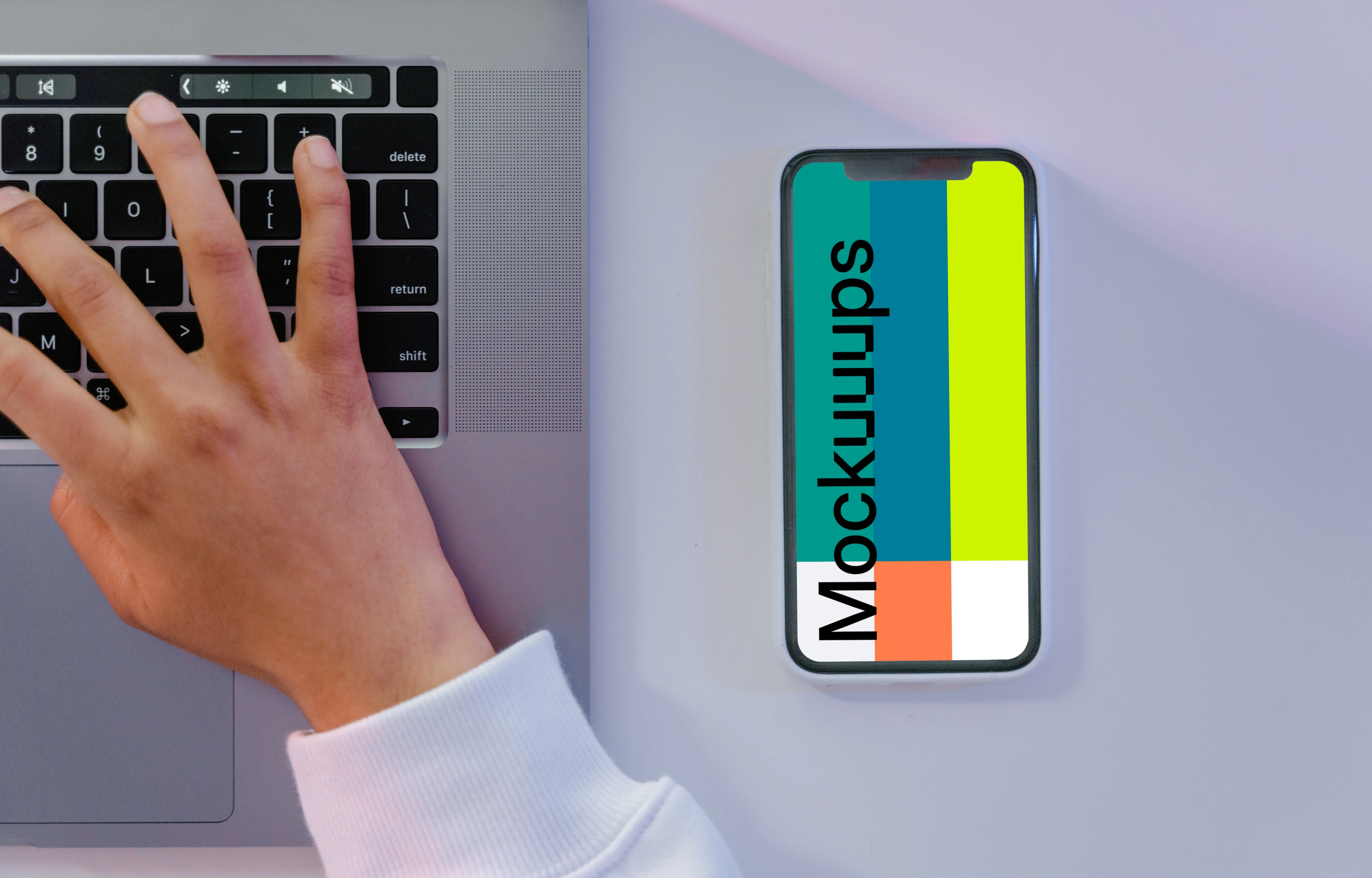 iPhone mockup beside grey MacBook