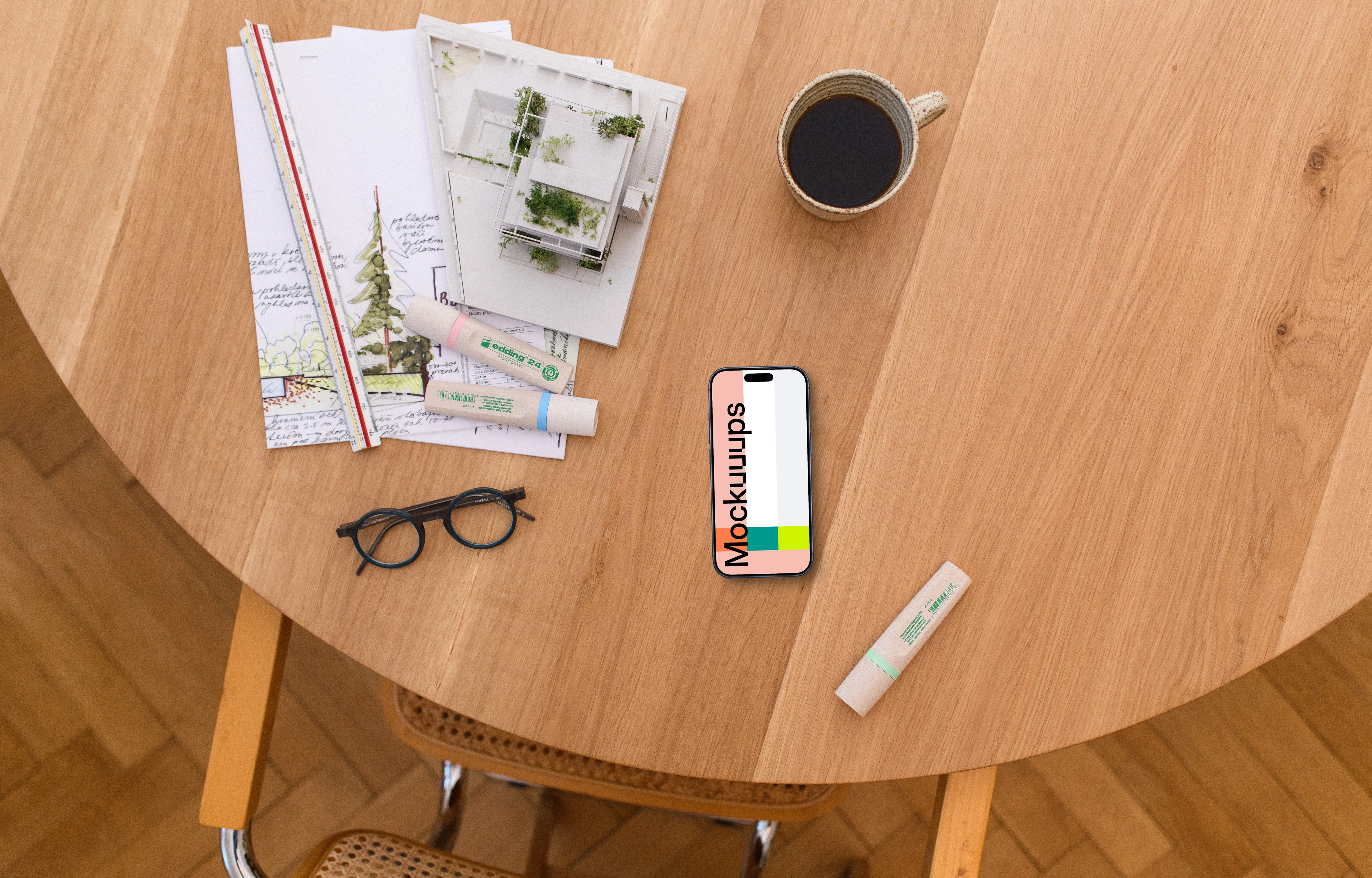 Smartphone mockup with architectural blueprints on wooden table