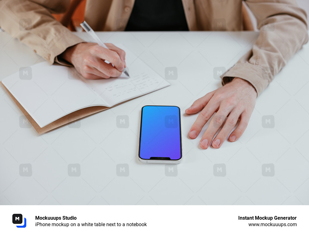 iPhone mockup on a white table next to a notebook 