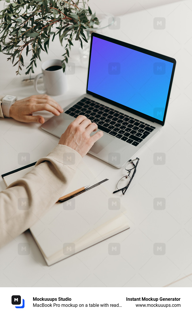 MacBook Pro mockup on a table with reading glasses by the side