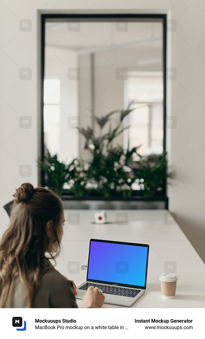 MacBook Pro mockup on a white table in use by a woman