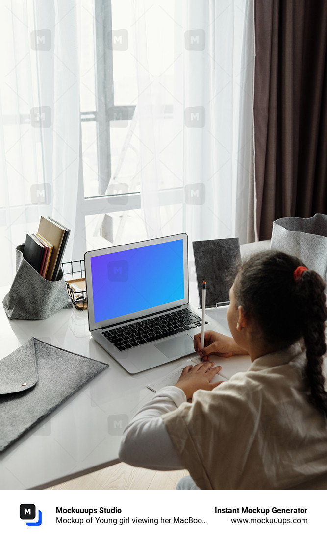 Mockup of Young girl viewing her MacBook Air screen and writing in a book