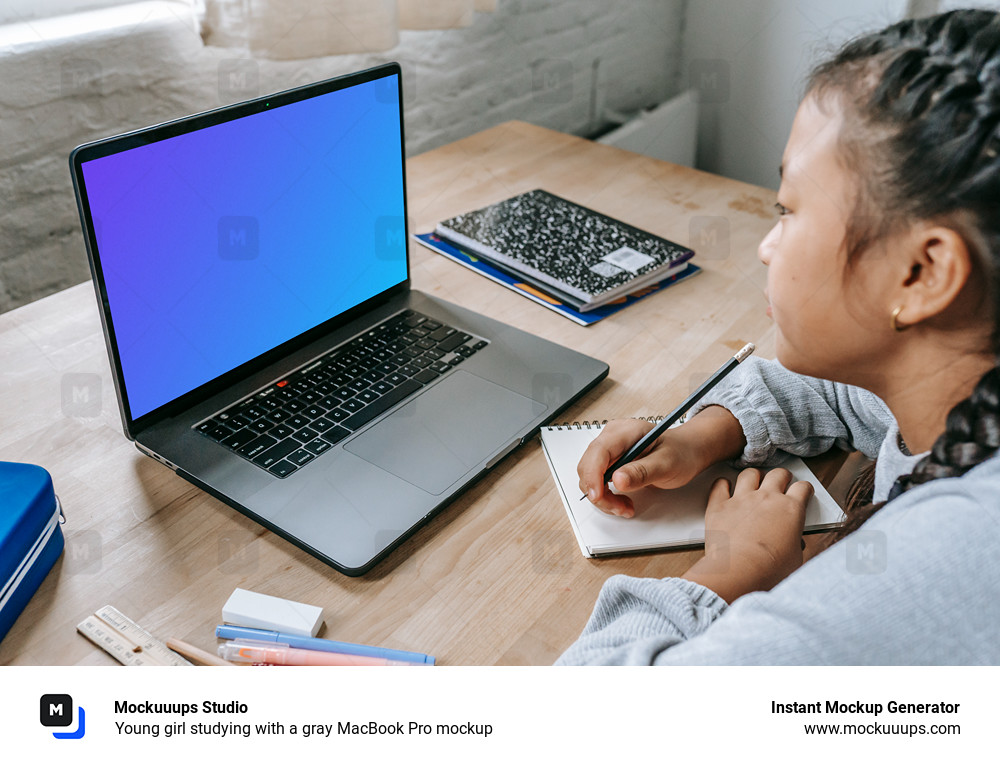 Young girl studying with a gray MacBook Pro mockup