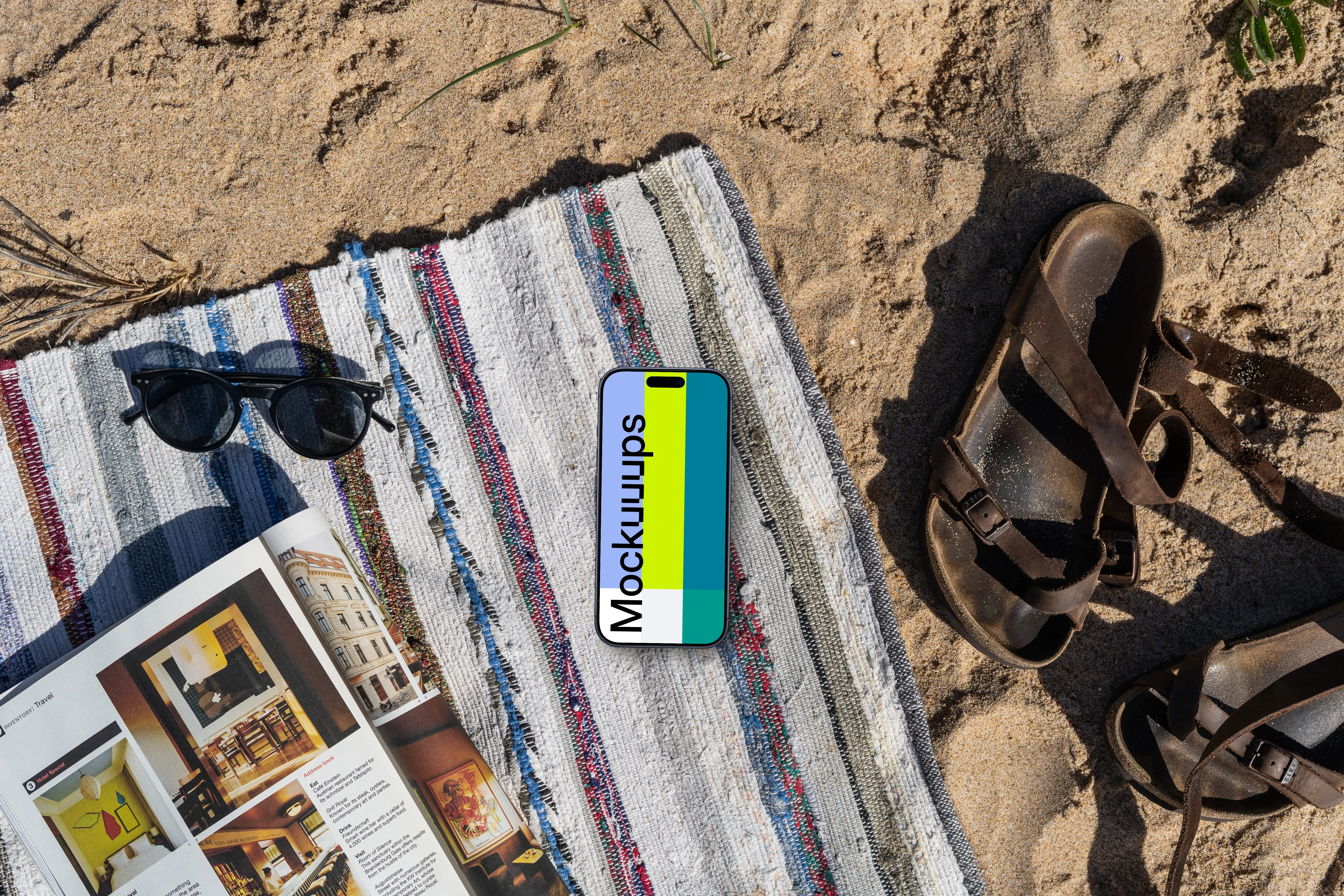 A smartphone mockup laying on a blanket in the sand