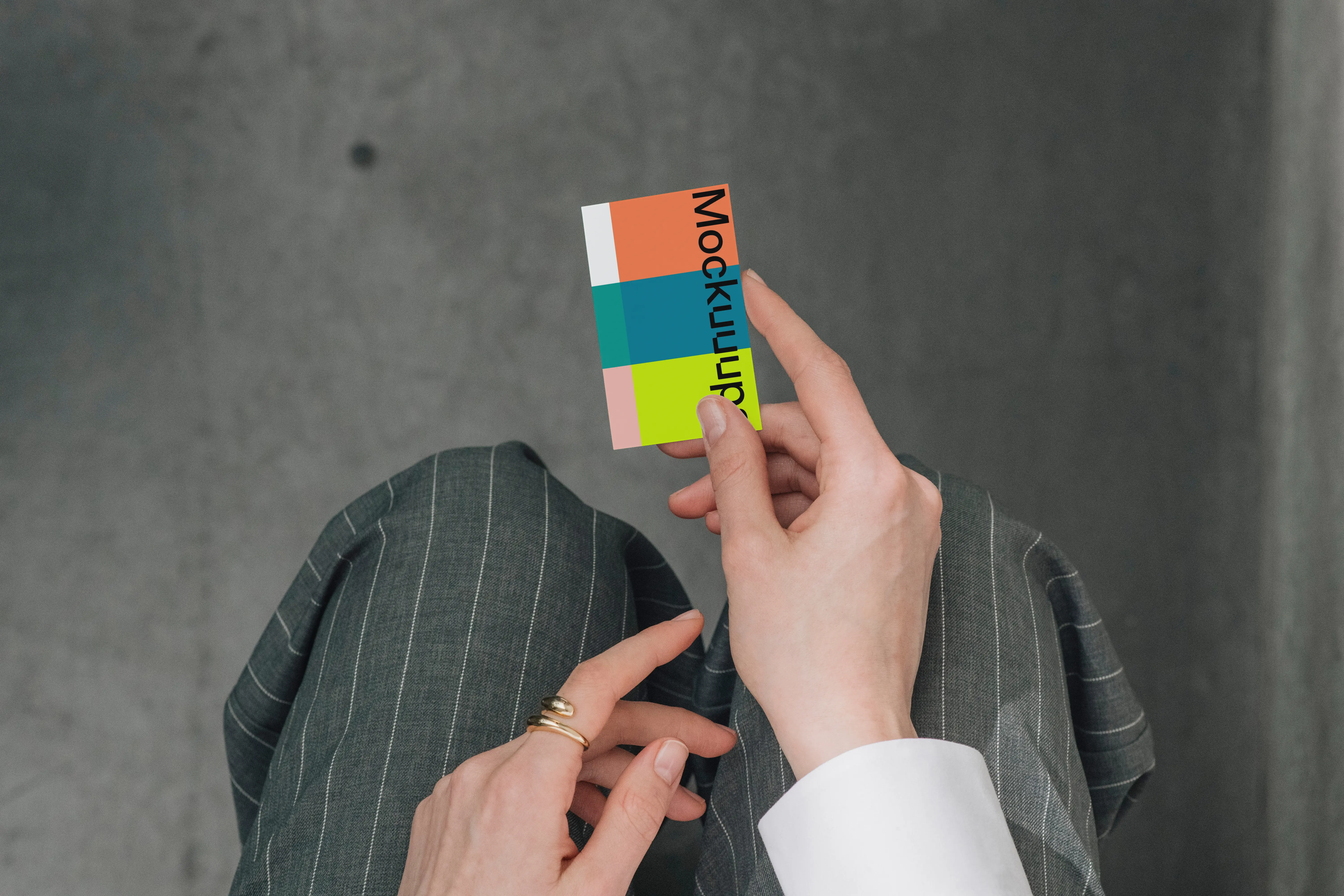 Business card mockup held over a pinstripe suit