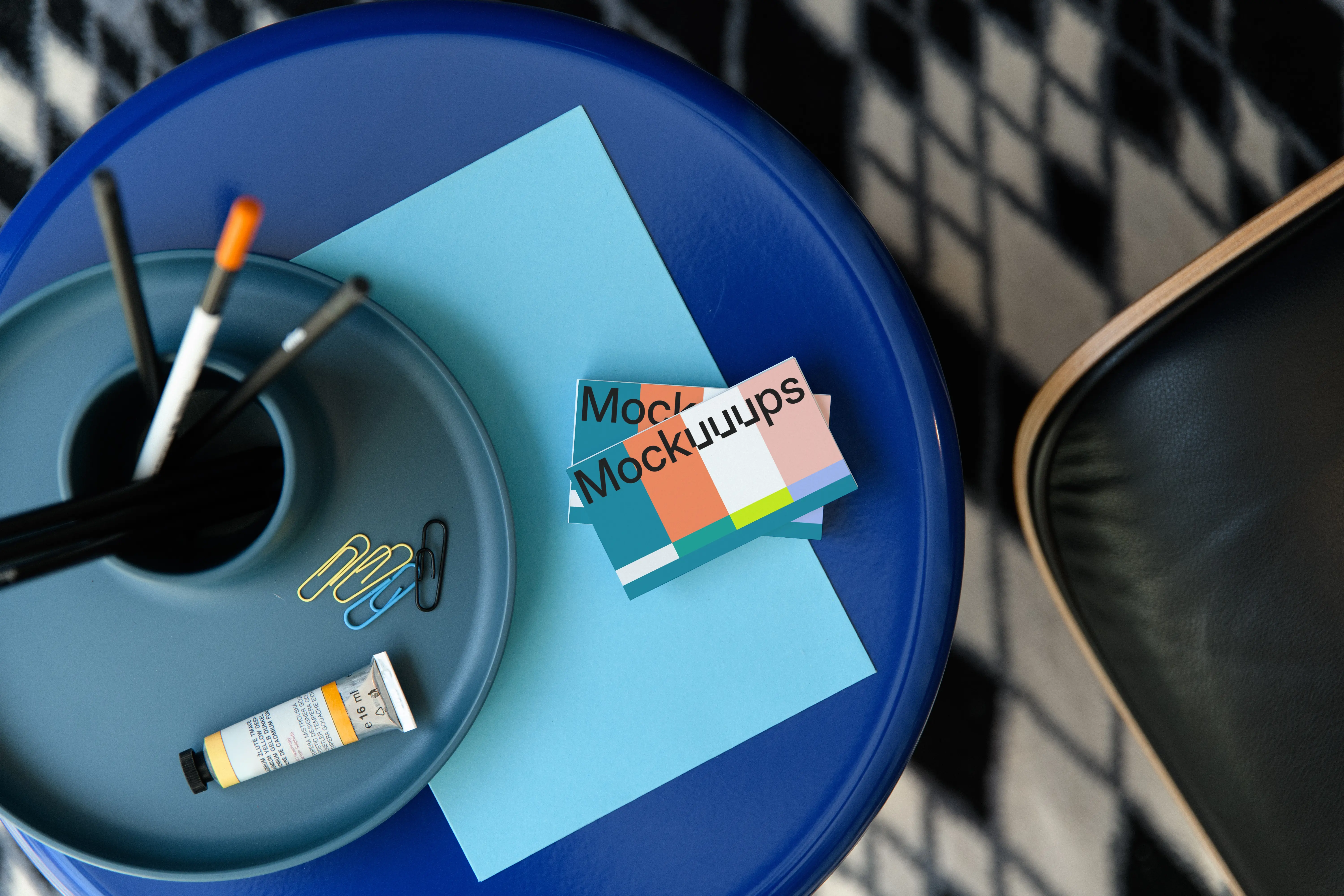 Business card mockup on a blue table with stationery