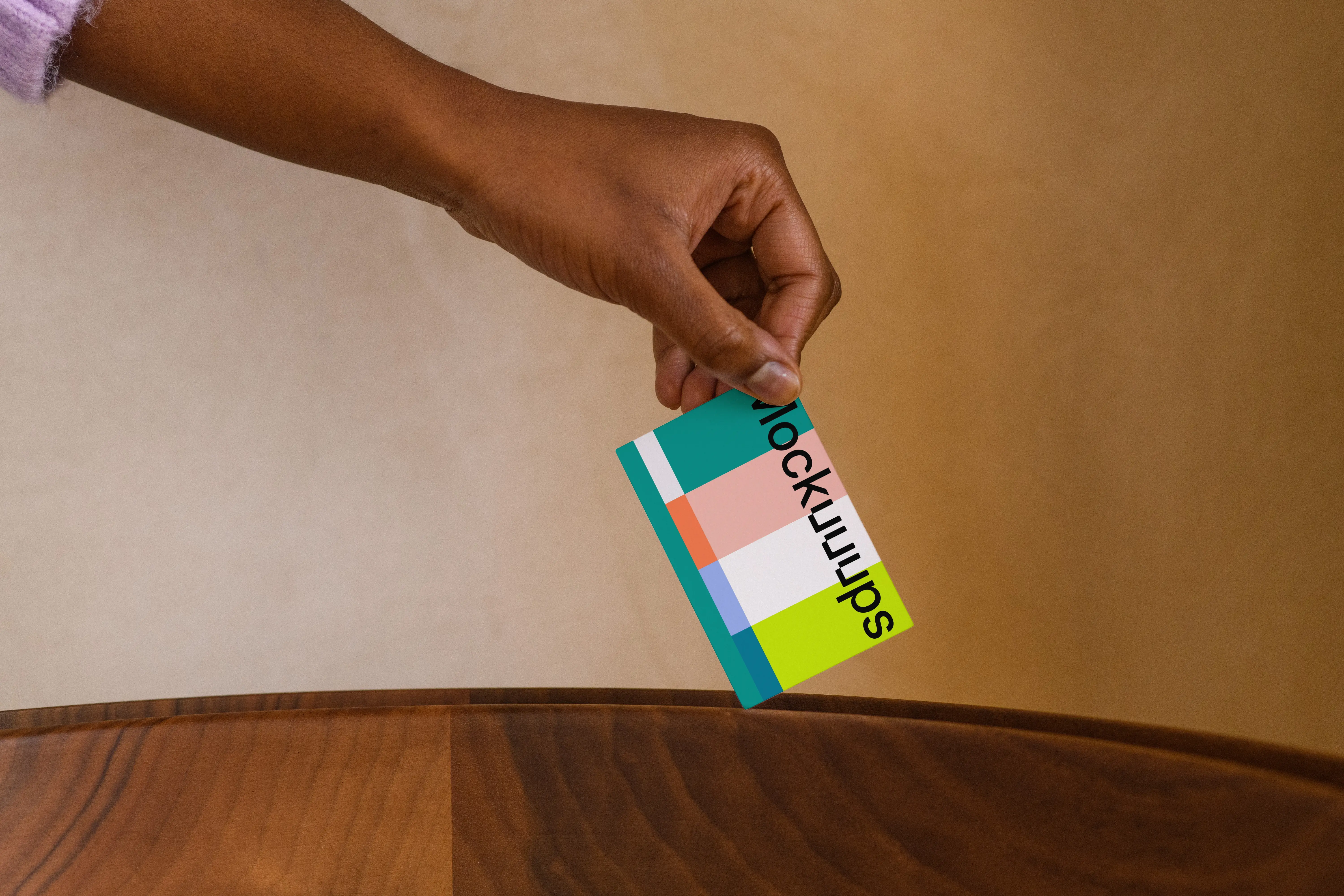 Business card mockup with hand over wooden surface