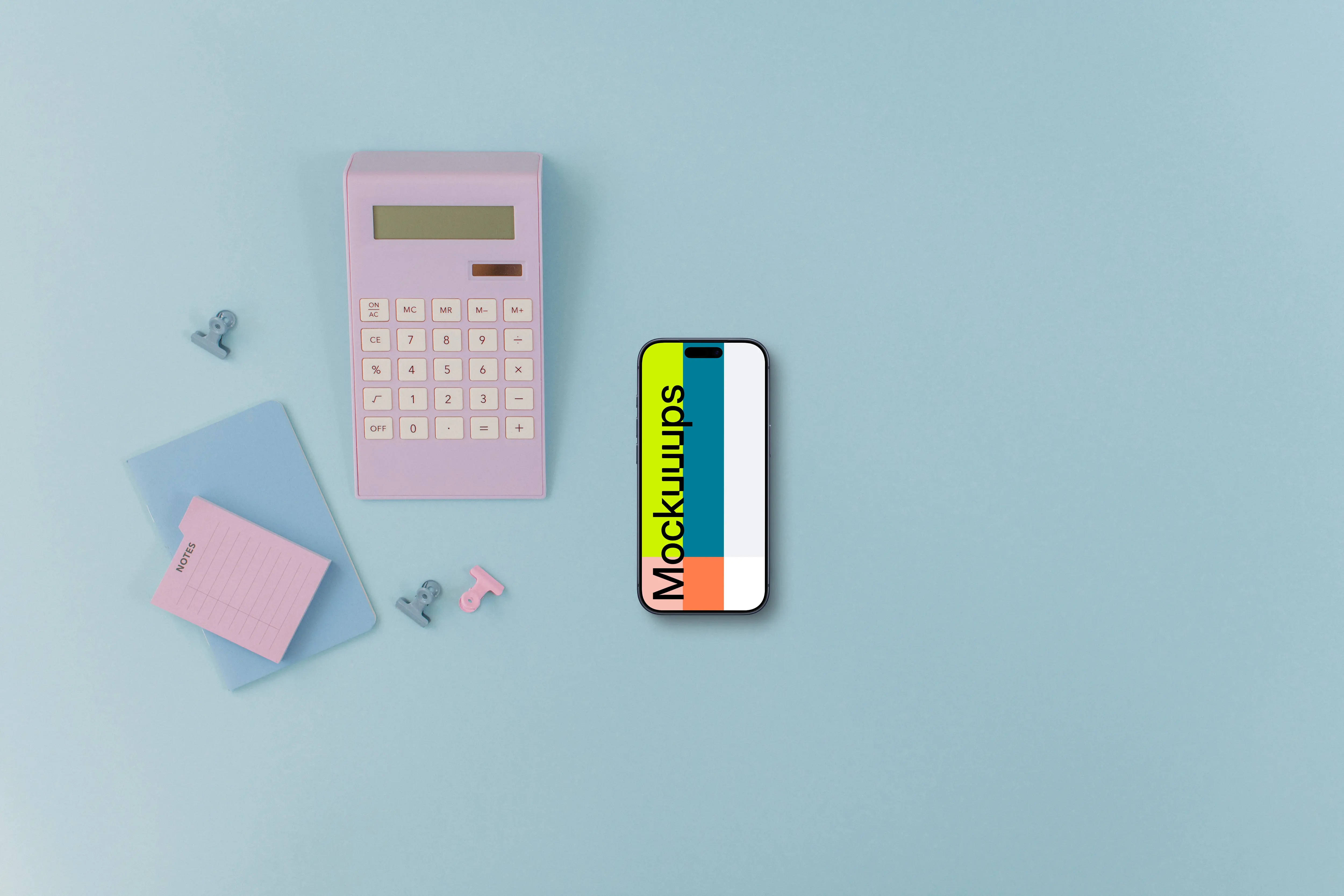 Calculator, small notebook and an iPhone on blue background
