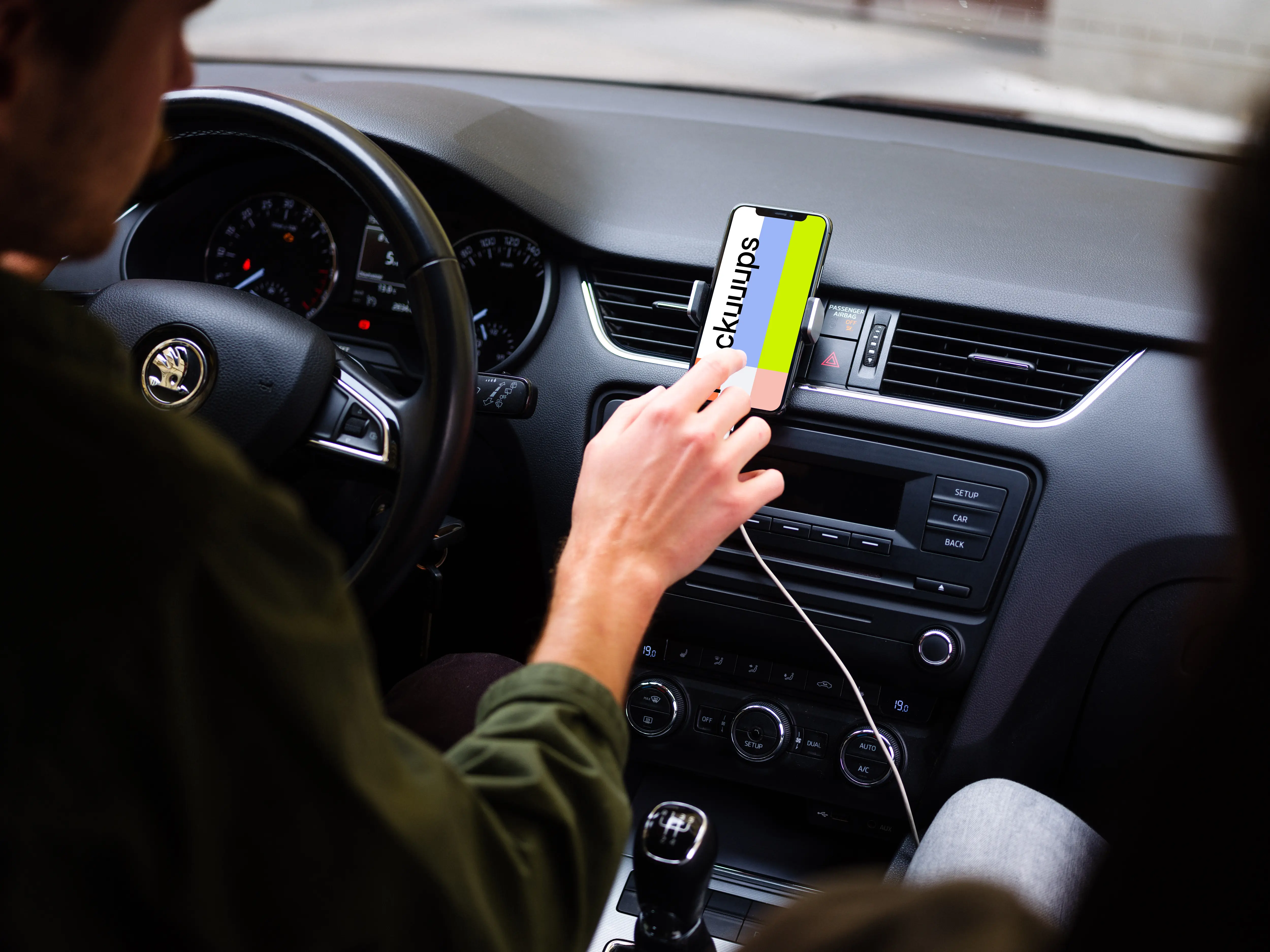 Car driver tapping iPhone 11 mockup in parked car