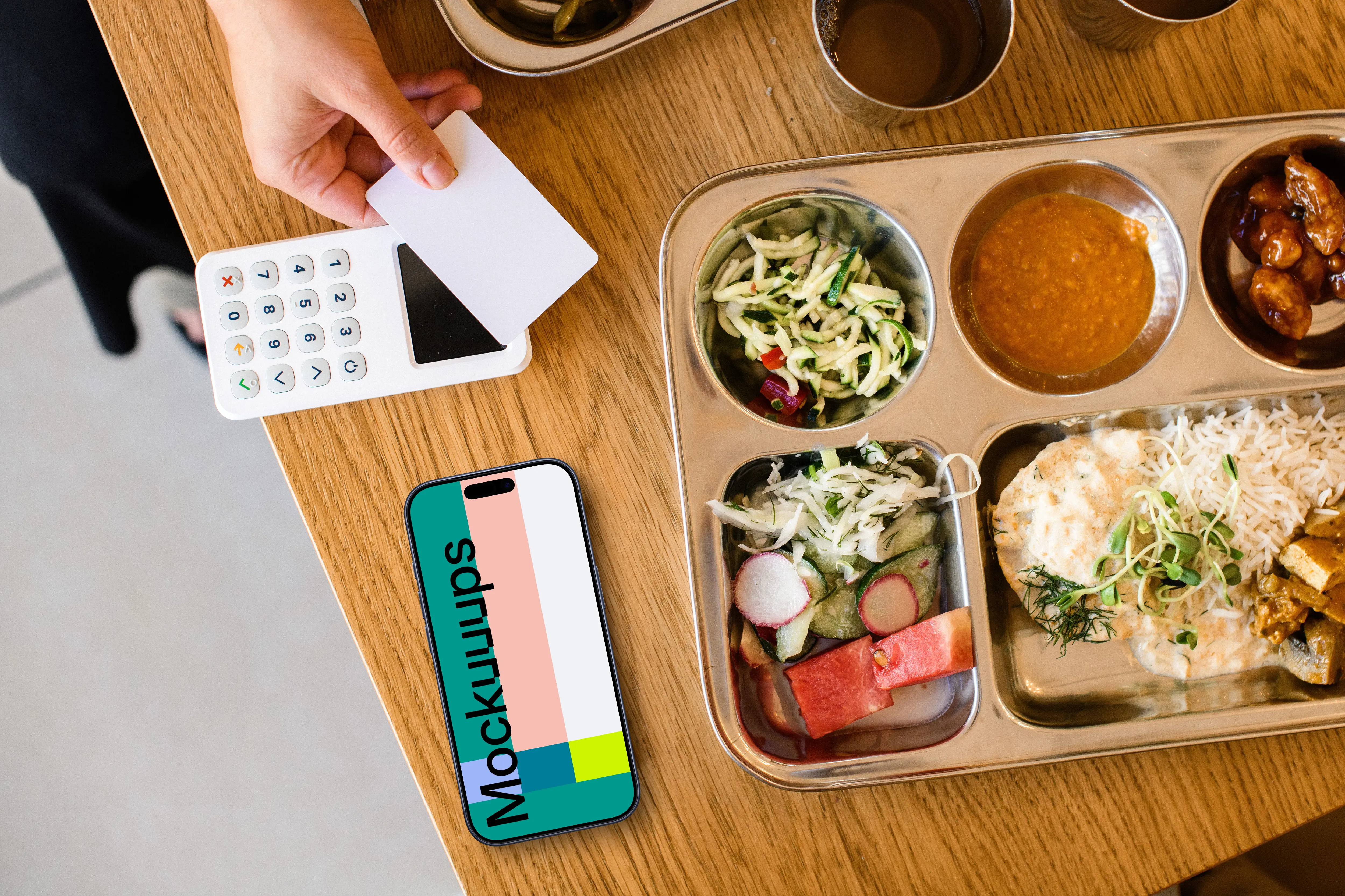 Food plate next to the iPhone mockup and payment terminal