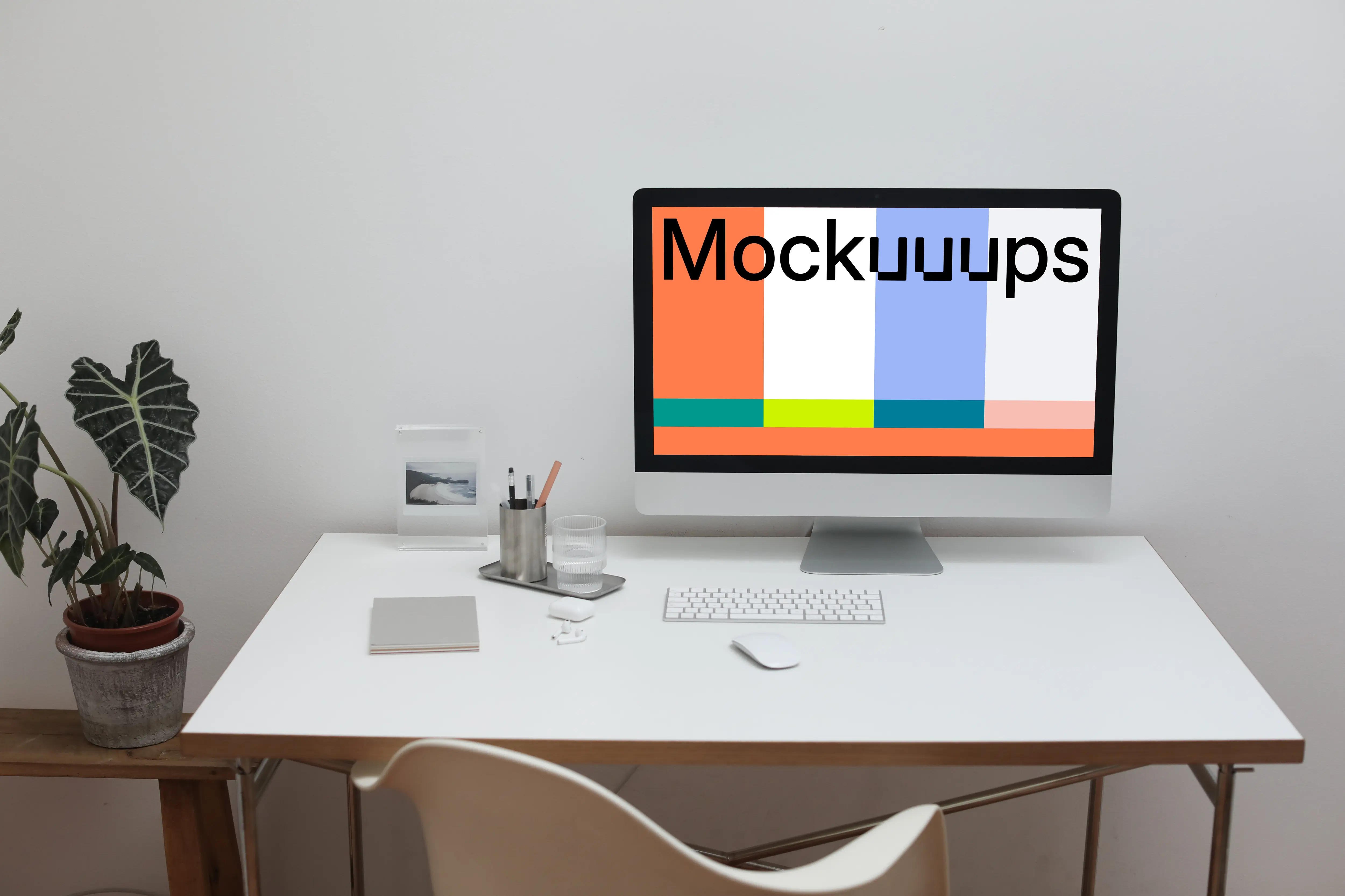 iMac mockup on a white table with a flower pot by the side