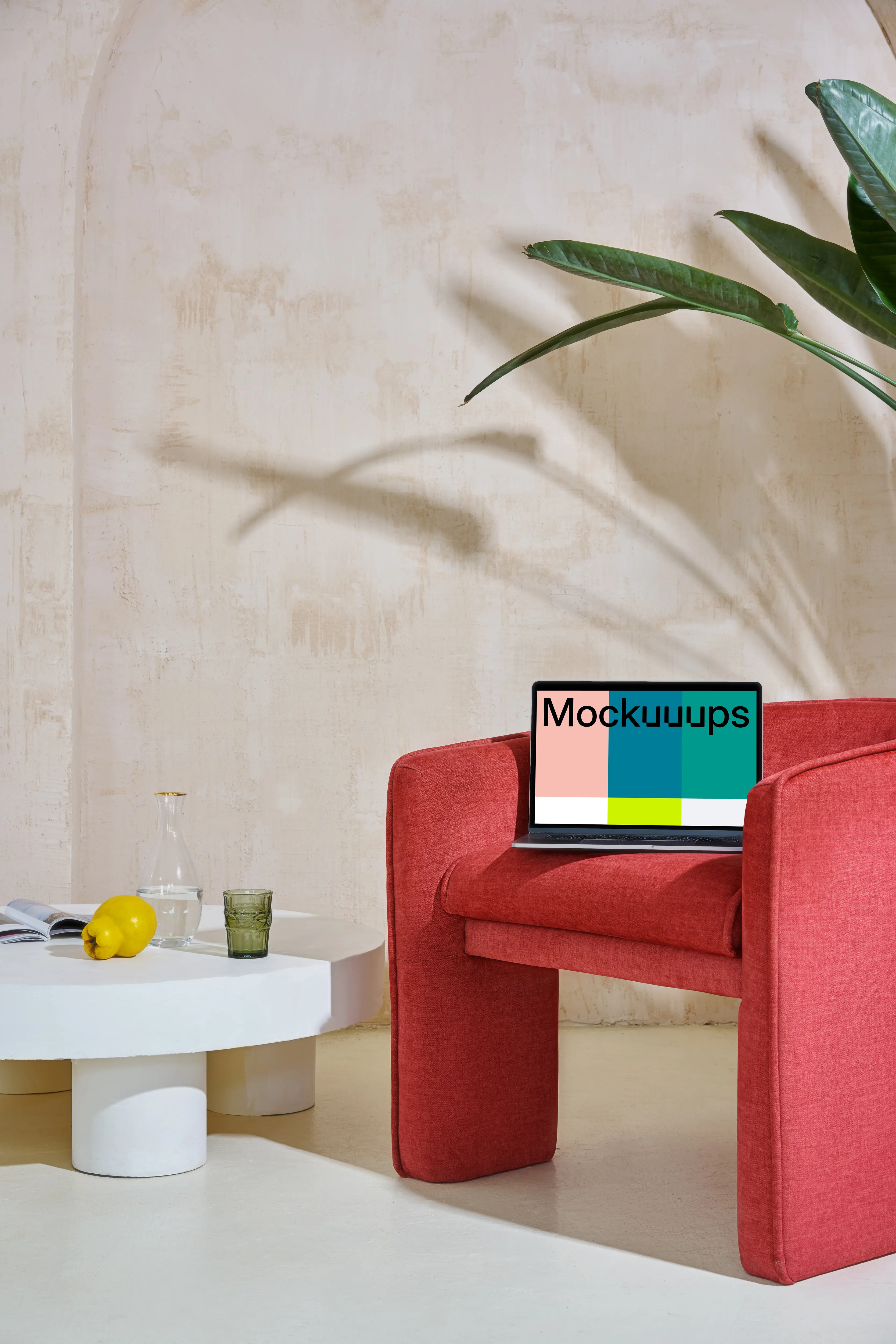 MacBook mockup on a red couch with a center table close by