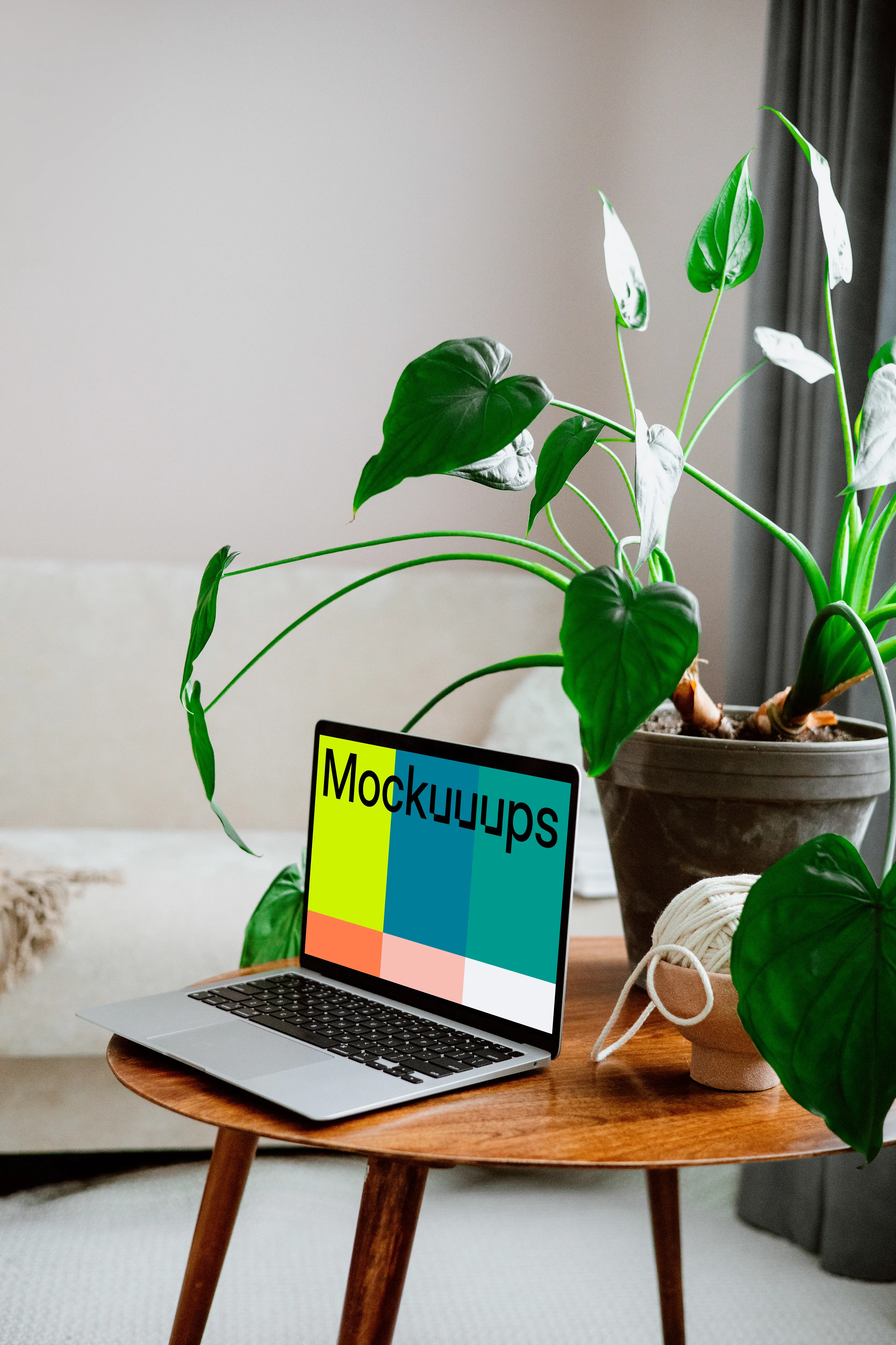 MacBook mockup on a wooden table with flower pot