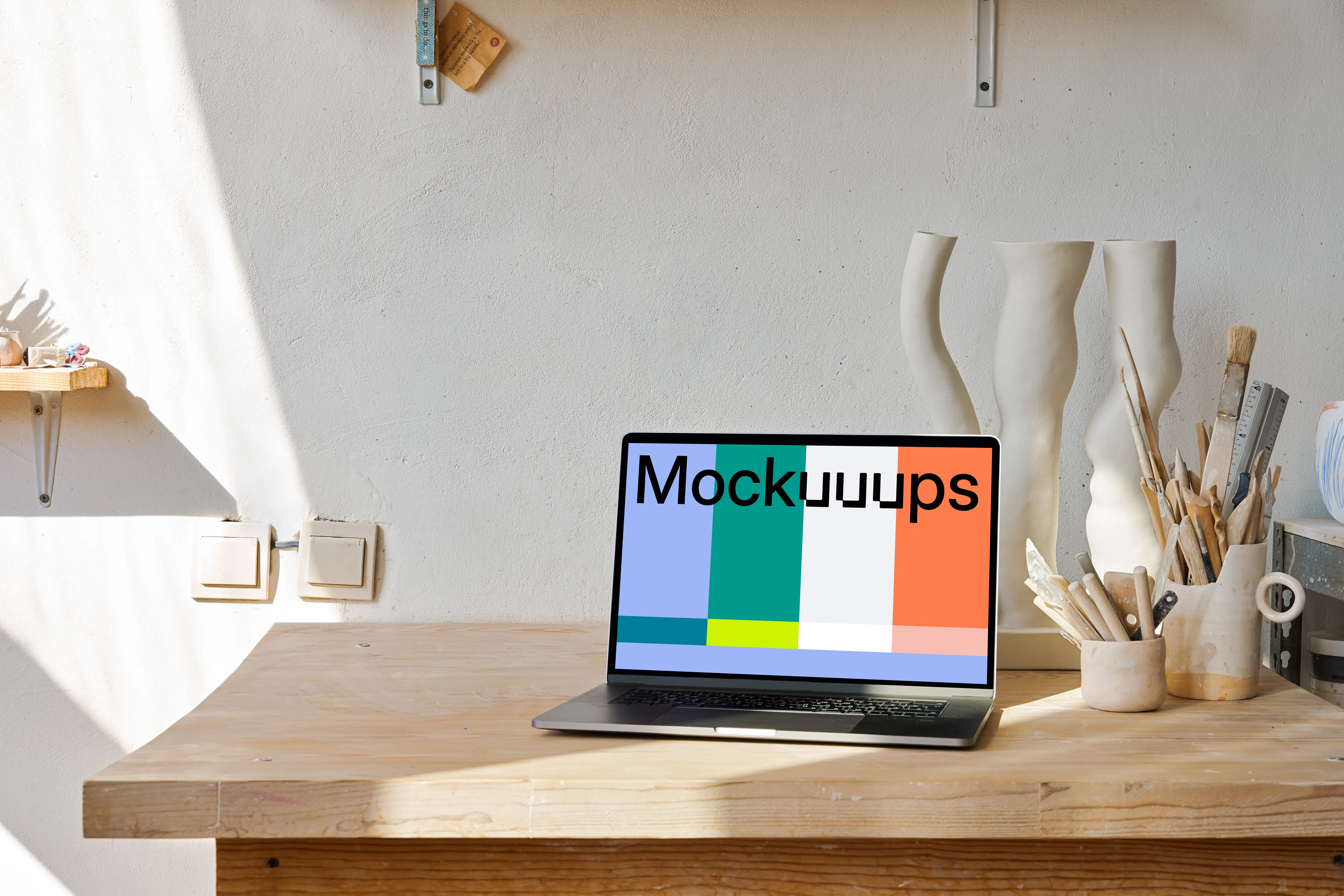 MacBook mockup on a wooden table with wooden art craft at the side