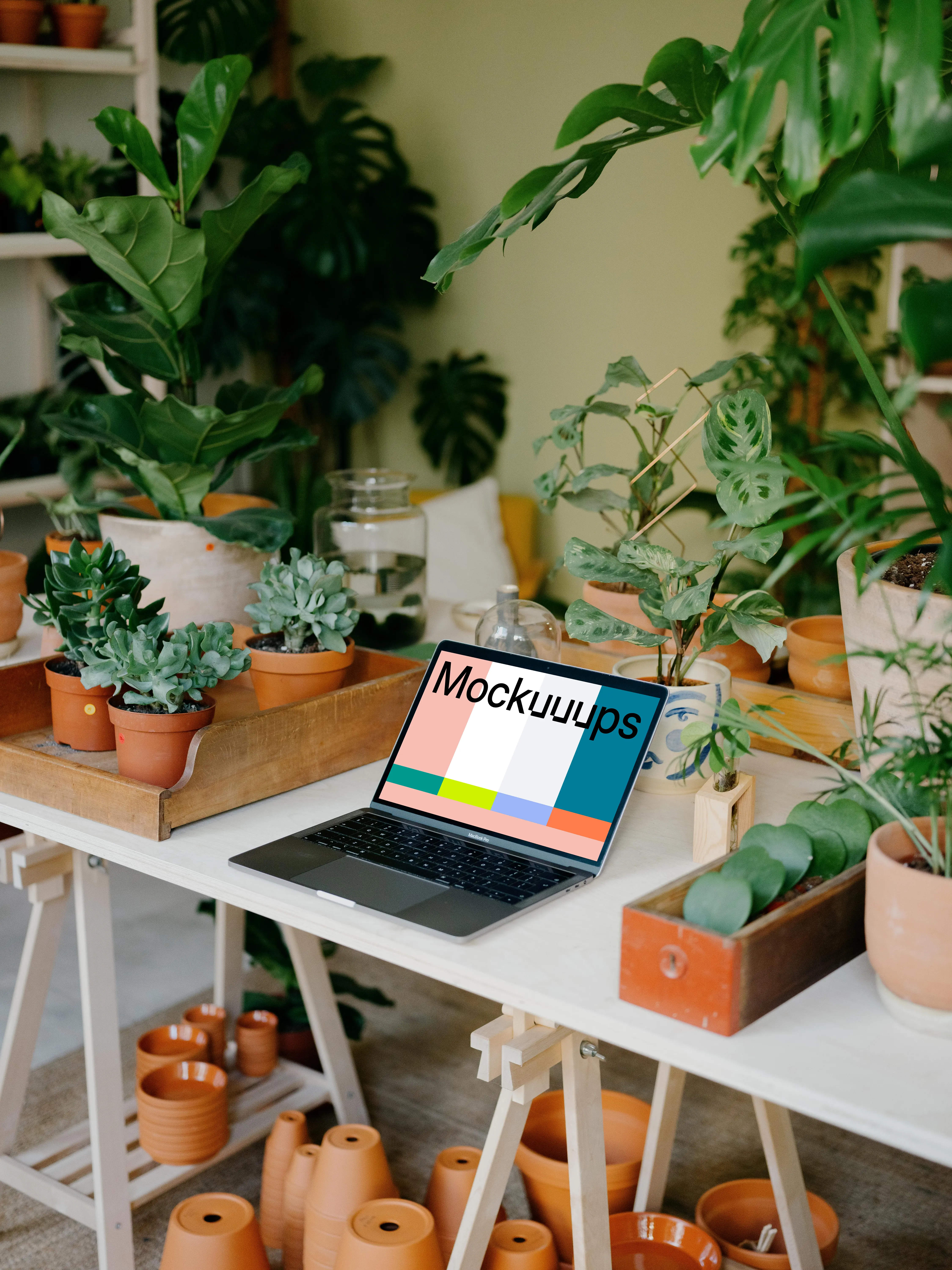 MacBook Pro Mockup between potted plants