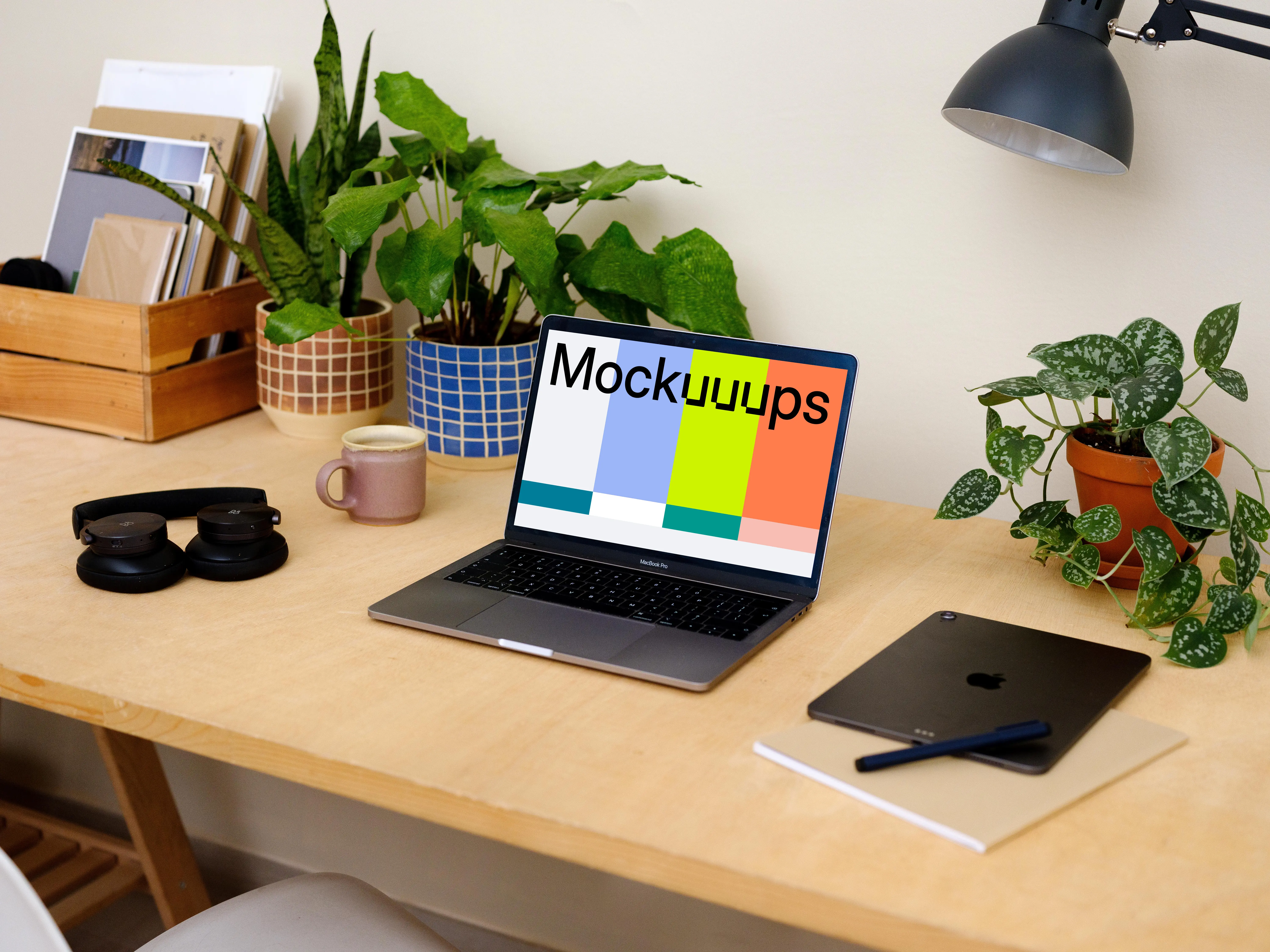 Macbook Pro mockup on a table beside a pair of headphones