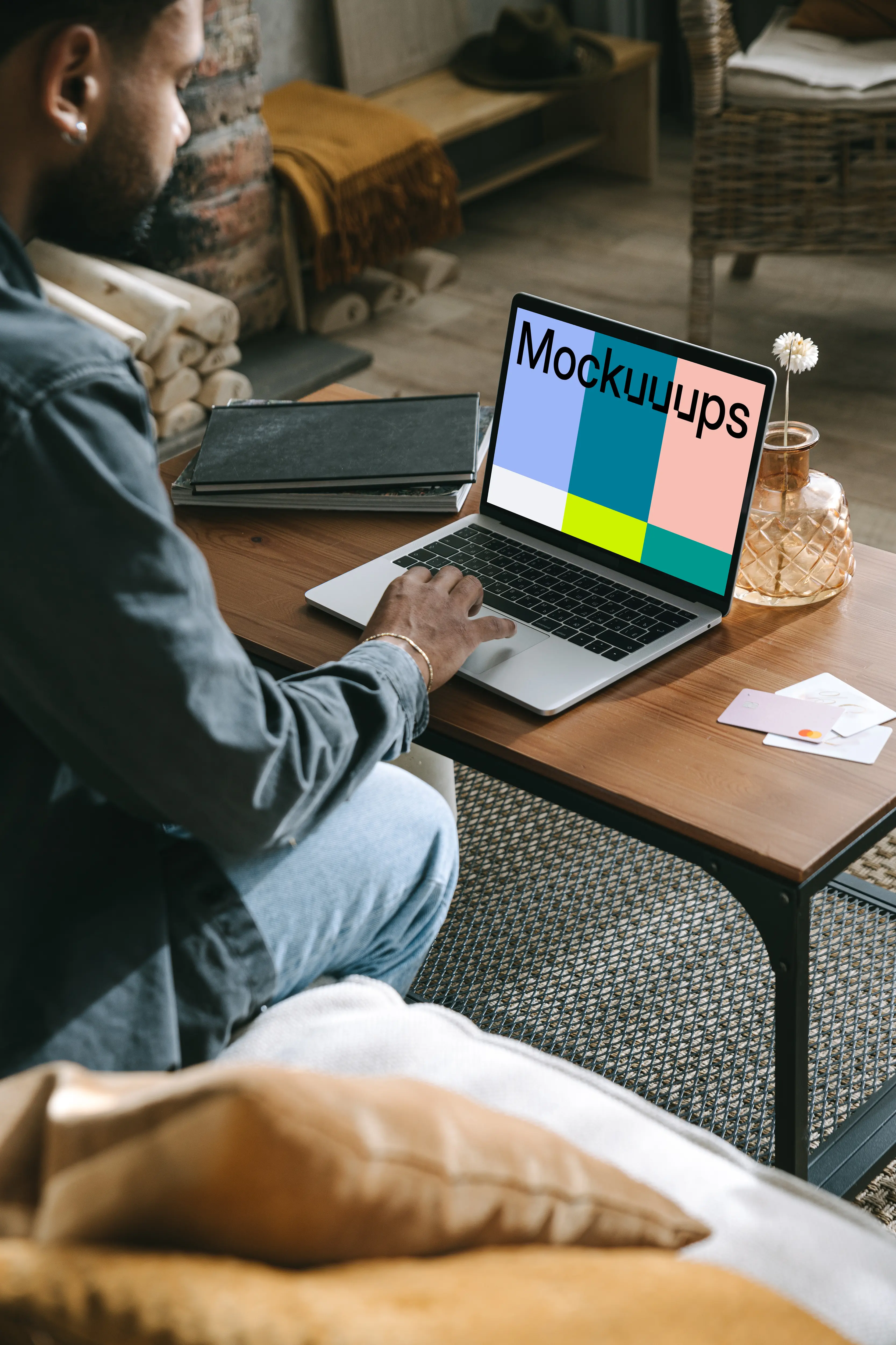 MacBook user shopping with a MacBook on the table and a debit card beside it mockup.