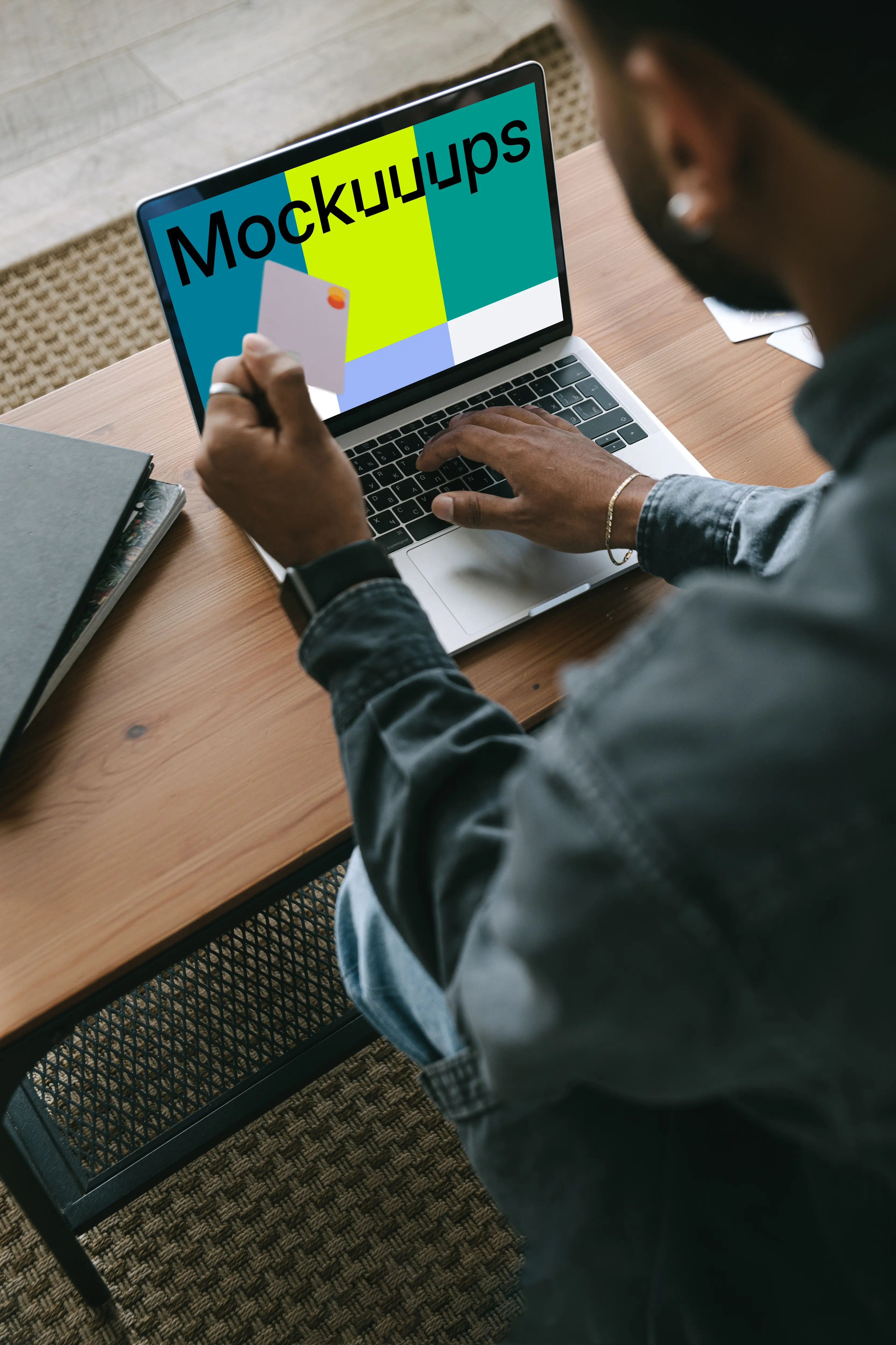 Man in grey shirt shopping mockup paying online with Mastercard on grey MacBook 