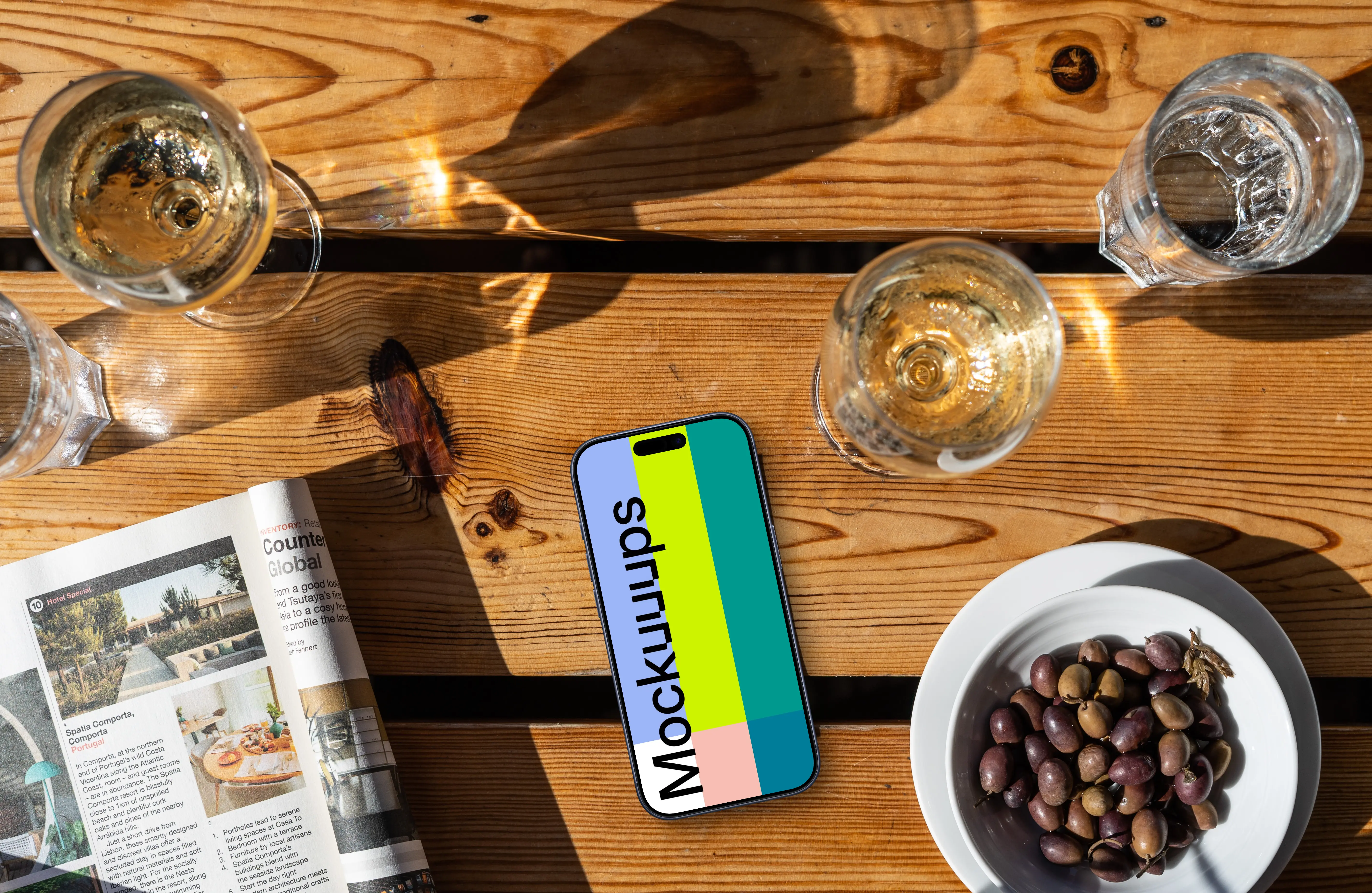 Smartphone mockup next to olives and wine