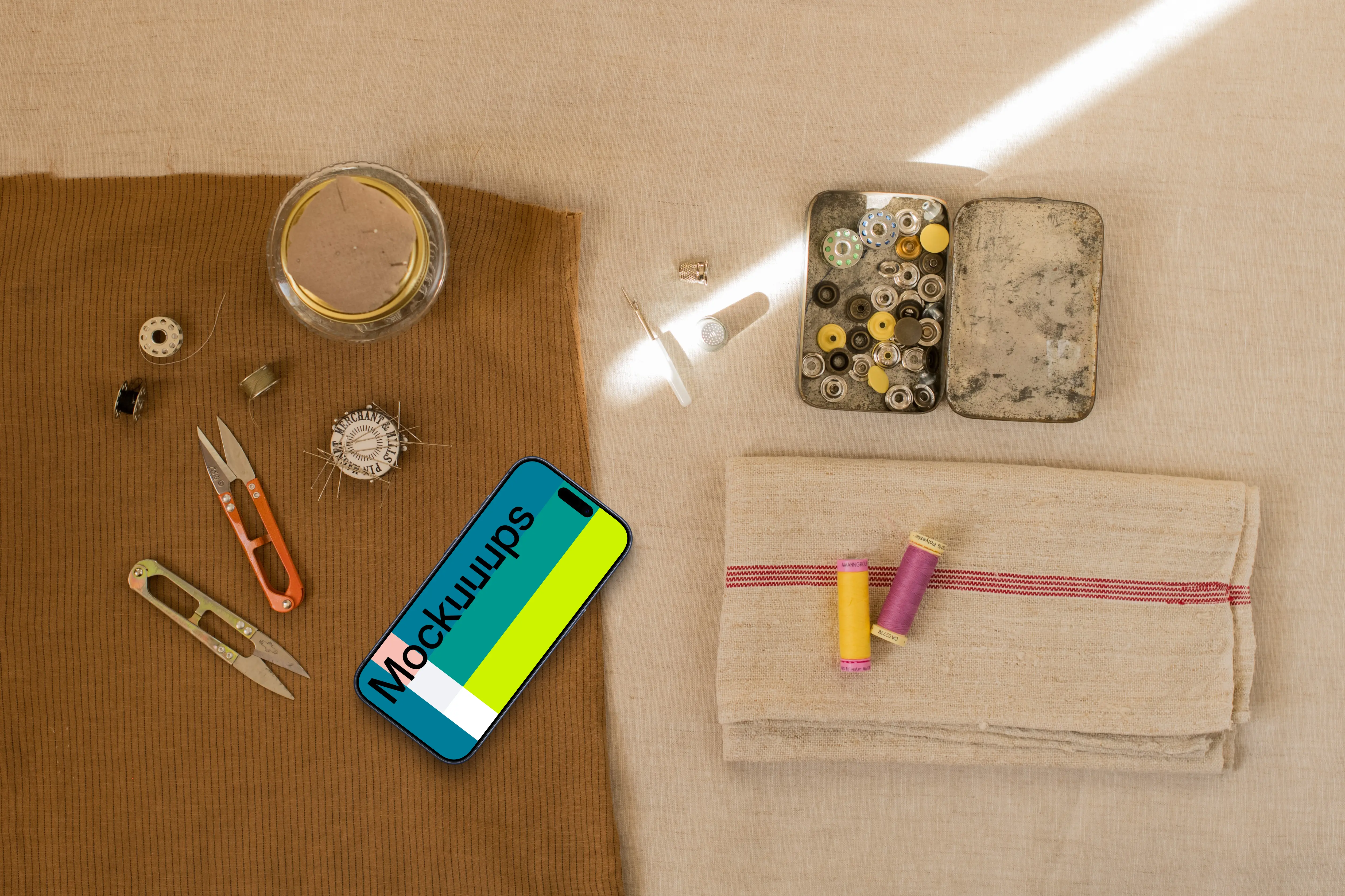 Smartphone mockup next to sewing accessories