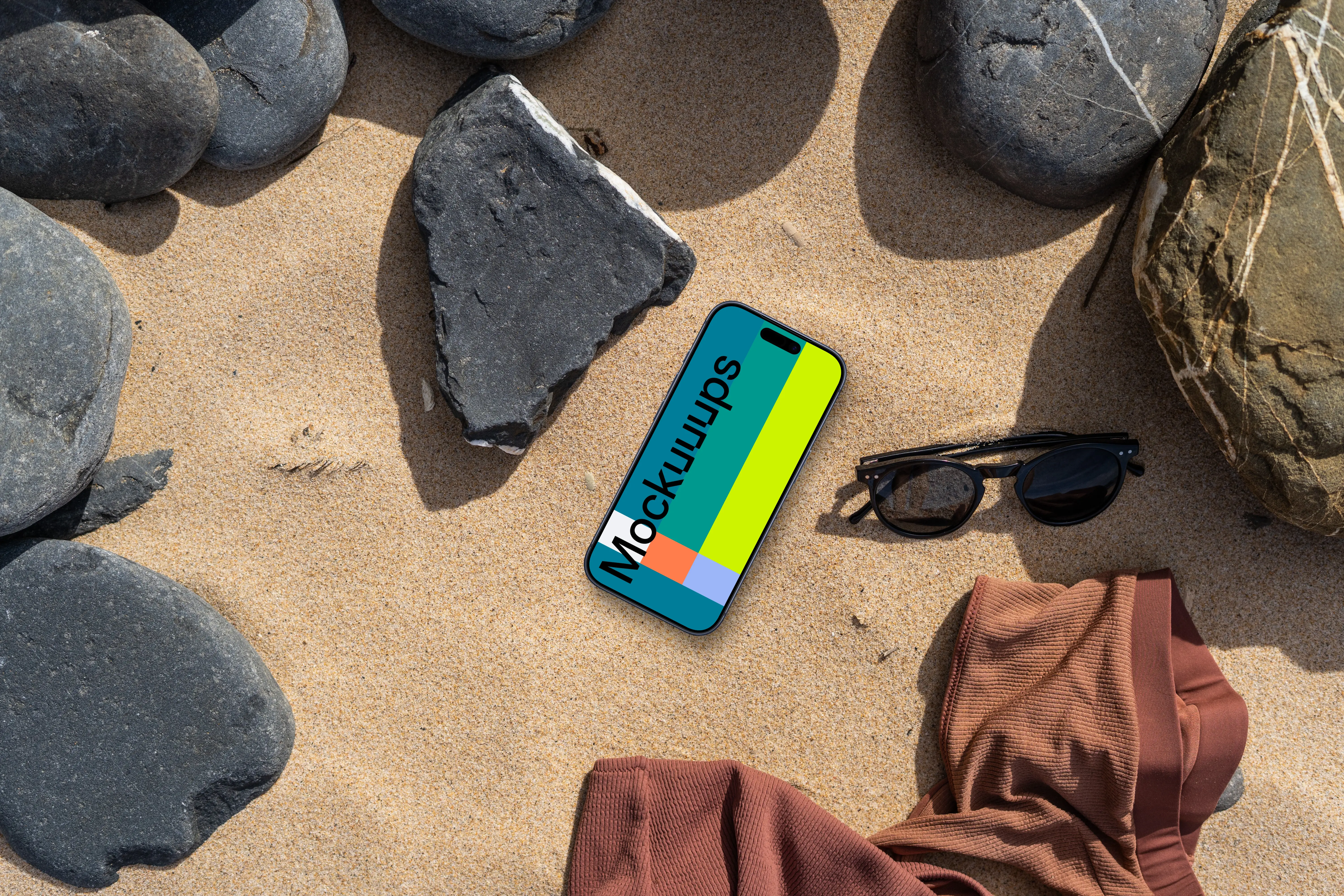 Smartphone mockup on a sandy beach with rocks