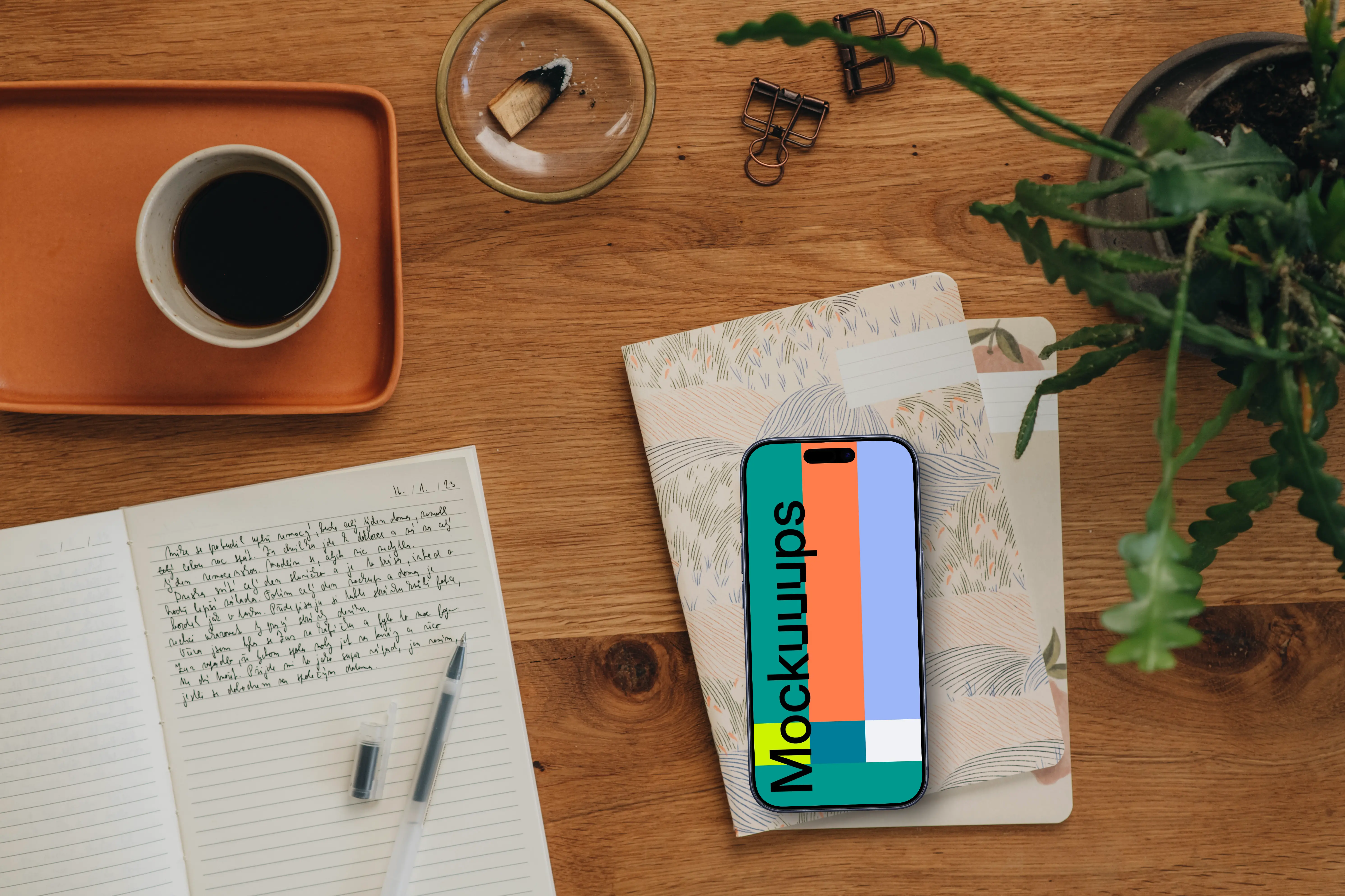 Styled journaling scene with an iPhone mockup