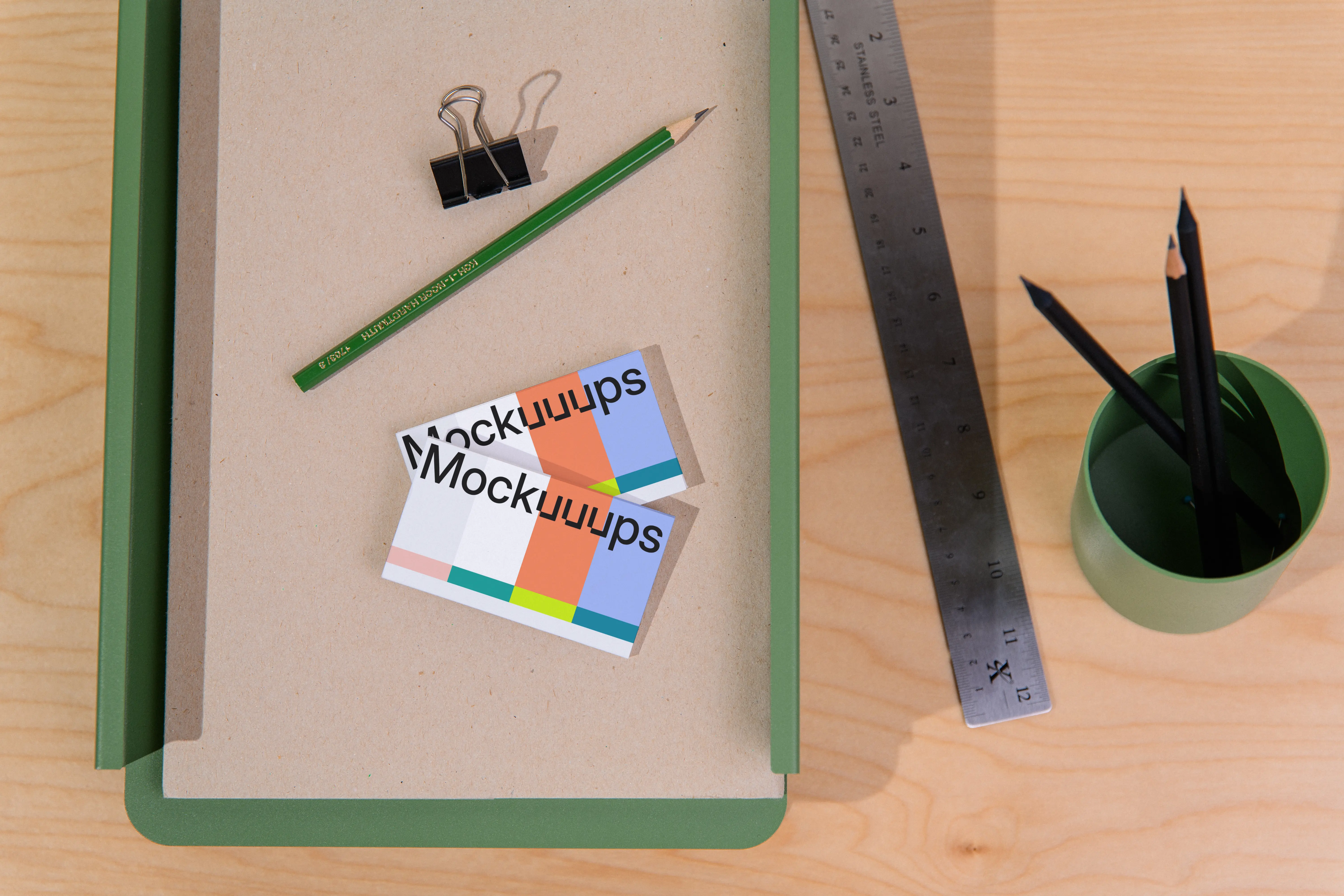 Two business card mockups on a desk with stationery
