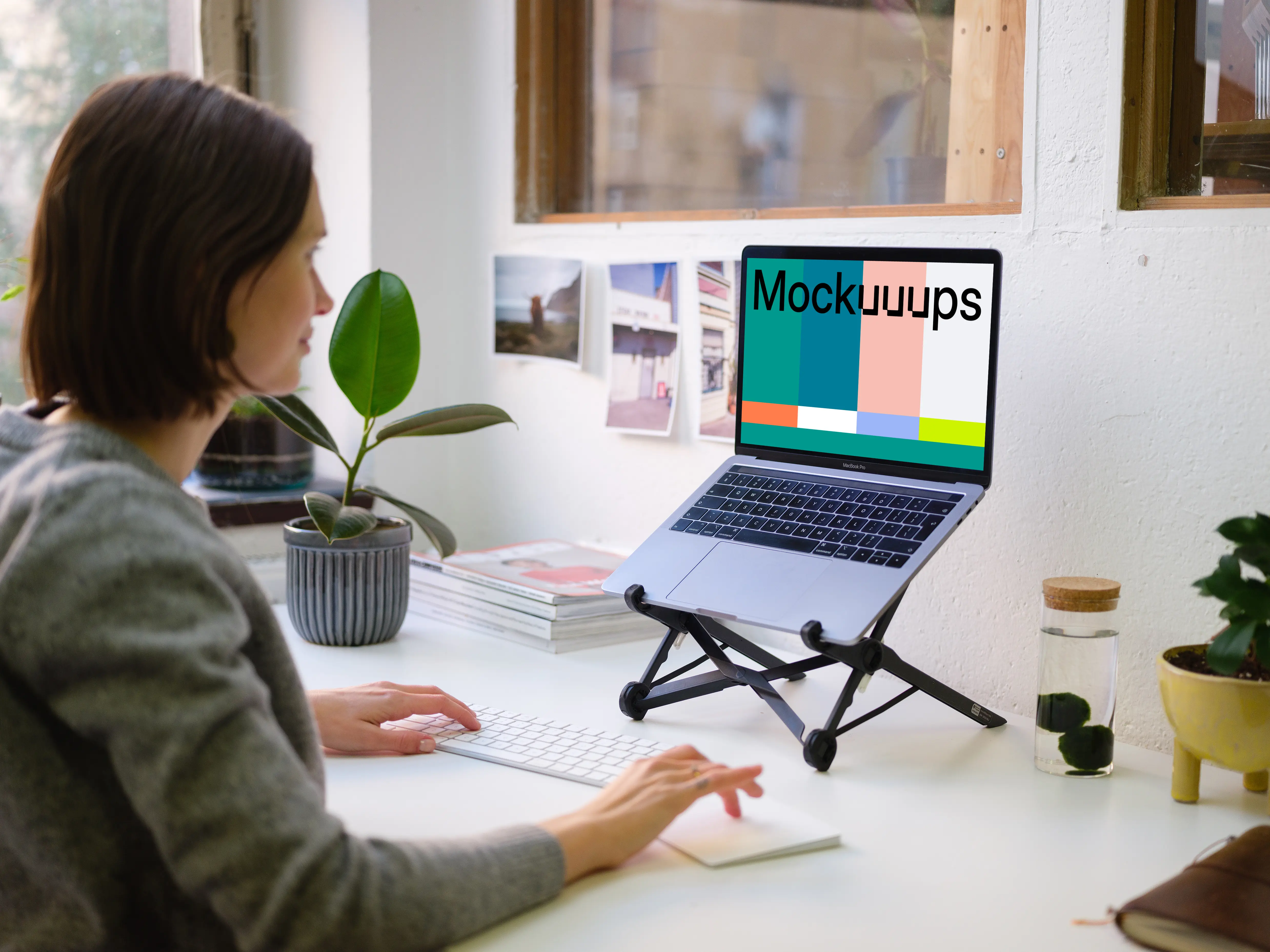 Young woman working on the Macbook Pro mockup in the bright office