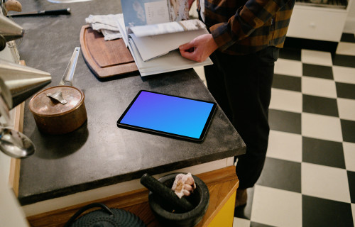 iPad Air mockup on a kitchen table beside a male user.