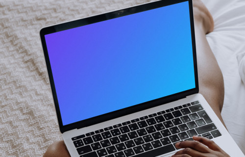 MacBook Pro mockup on a ladies lap sitting on a bed